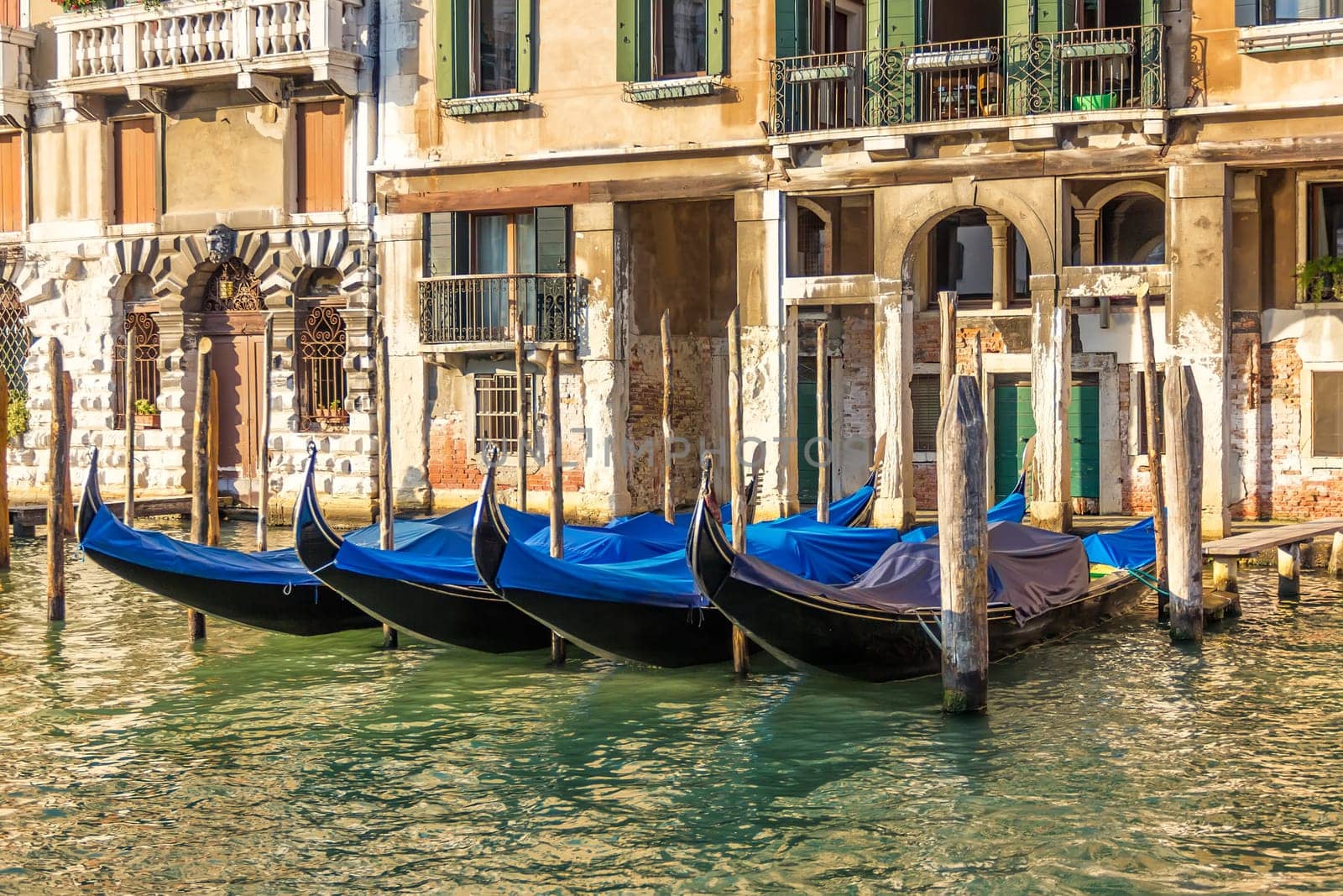Venice palace with gondolas moored in Grand Canal, Italy.