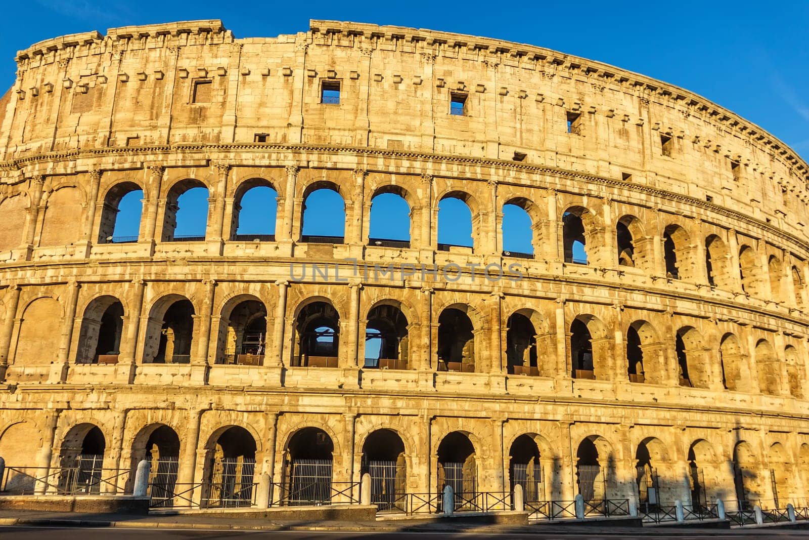 The Colosseum of Rome under the blue summer sky.