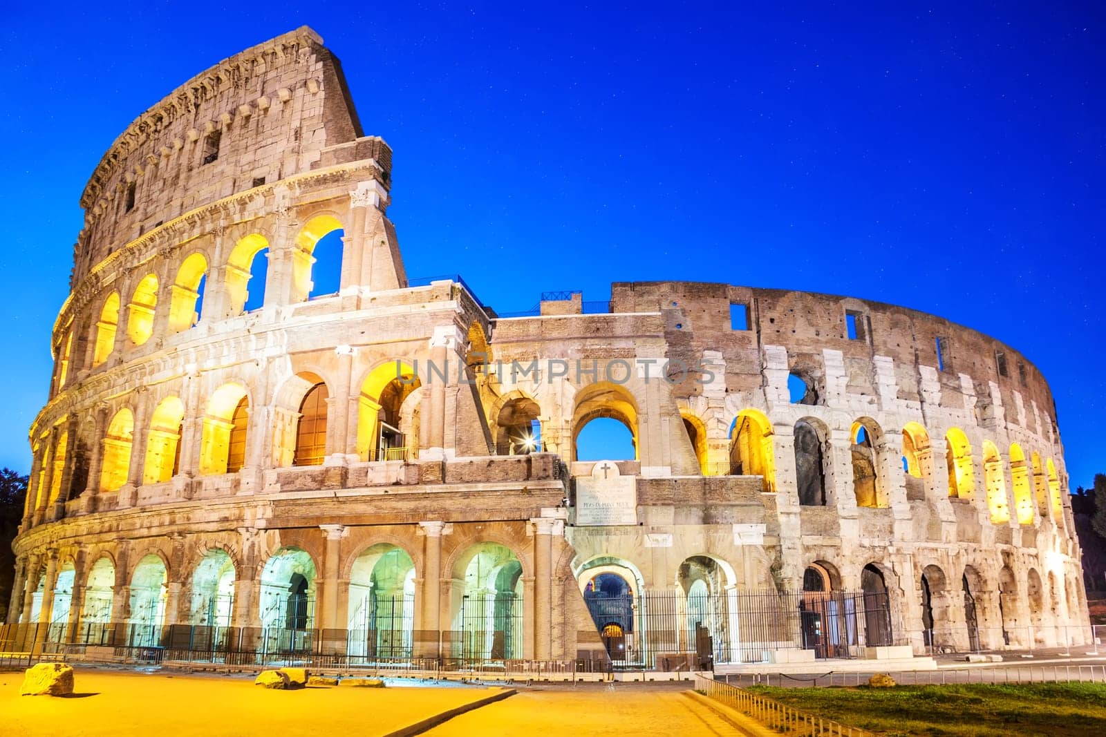 Coliseum in the evening in the lights under the starlit sky, Rome, Italy, no people.