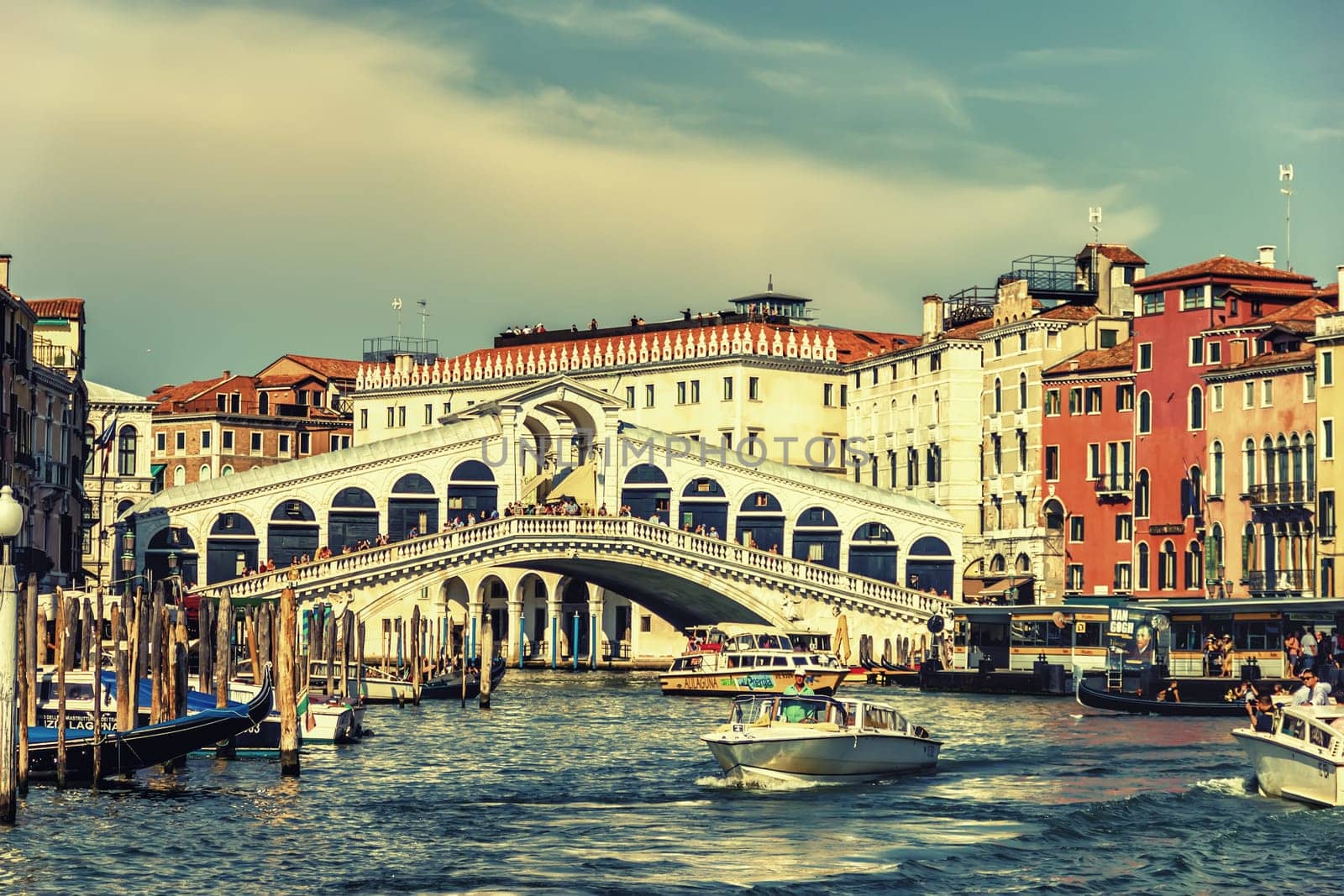 Venice, Italy - August 22, 2018: The Rialto bridge over the Grand Canal, tourists and boats.