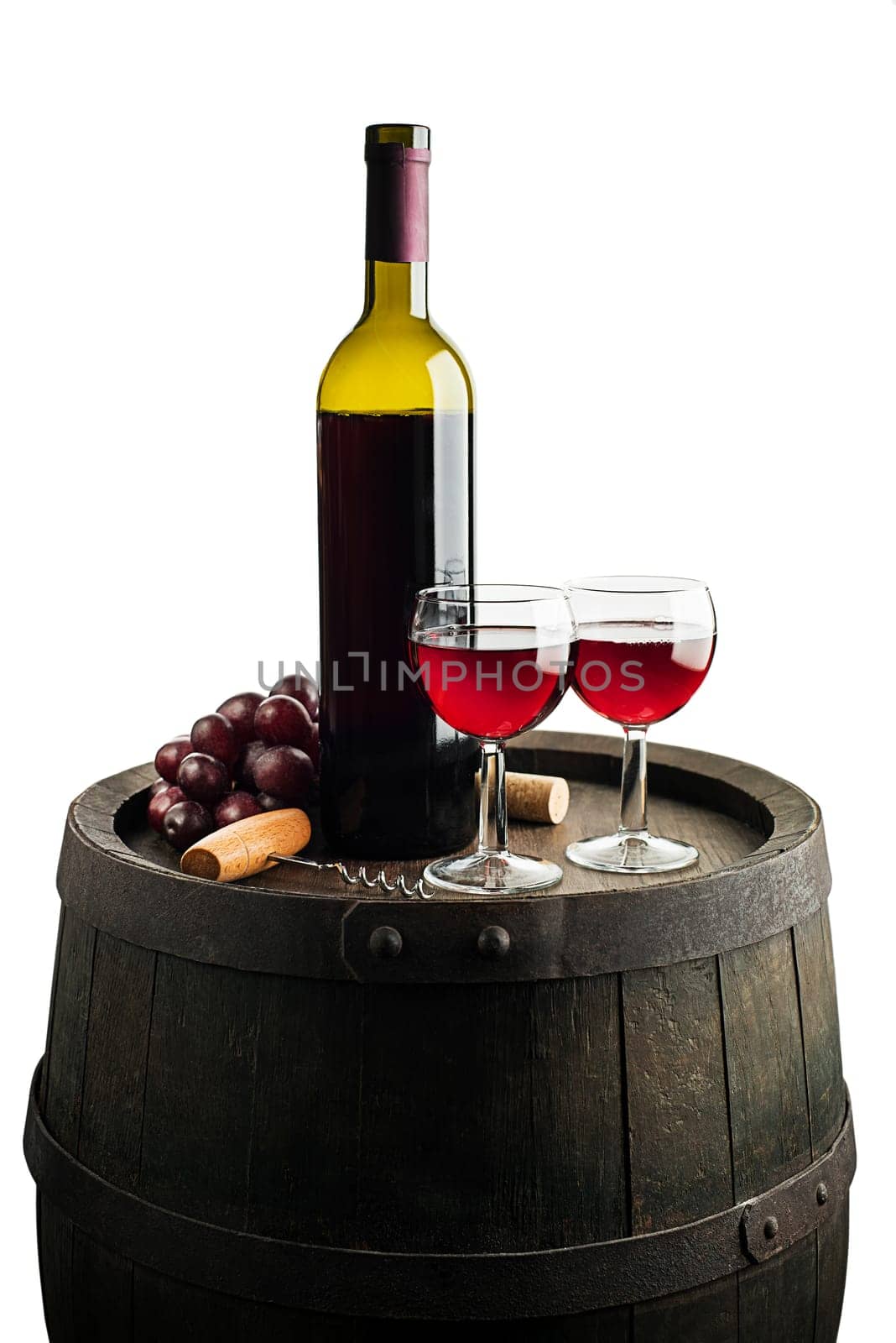 Glass and bottle of red wine on wooden barrel background isolated on white