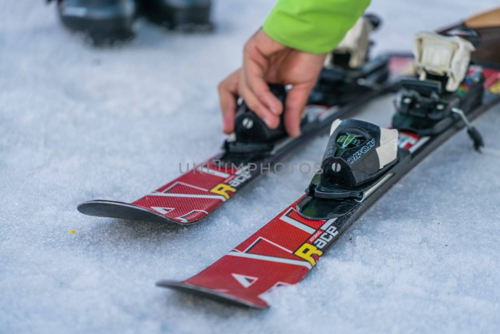 Szklarska Poreba, Poland - February 2019 : Ski instructor explaining the features of skis to his little student and adjusting the locking mechanism