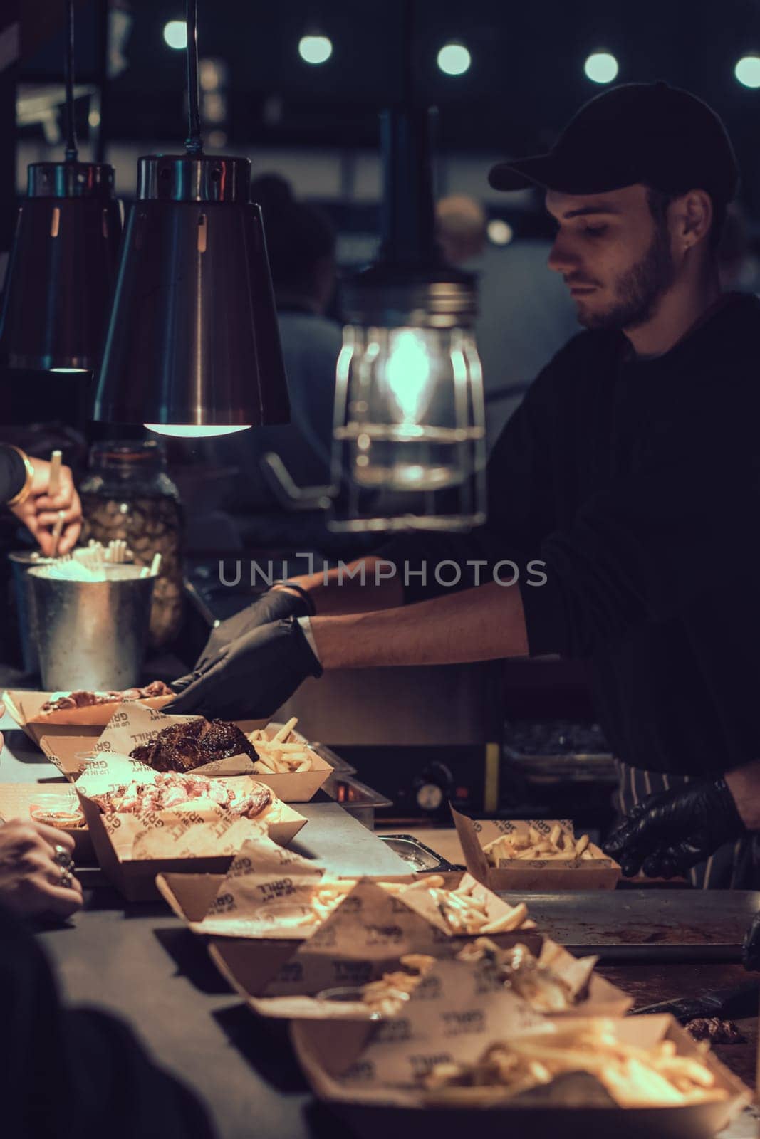 London, England - November 2018 : Men serving take away home made main meals on the street food market