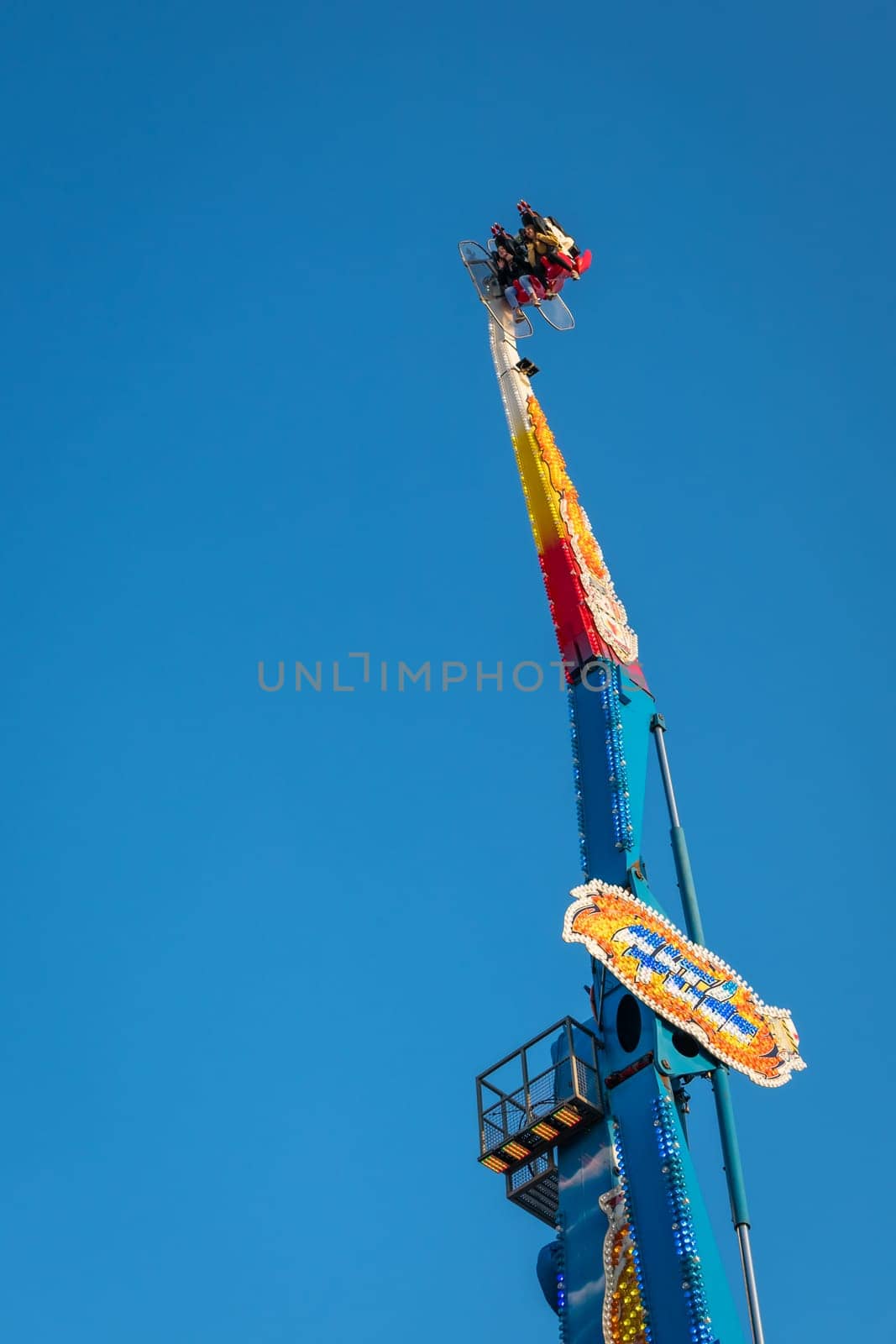 London, England - November 2018 : Riders on the scary ride high in the air on a sunny day in an amusement park