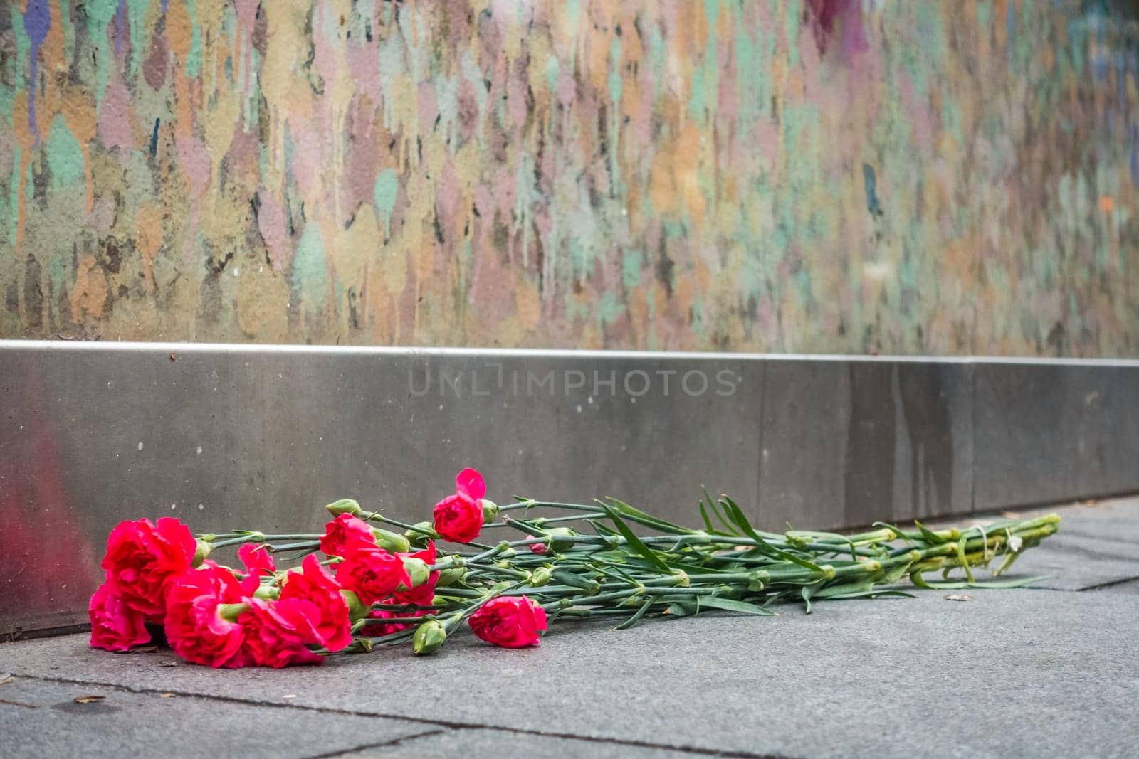 London, England - December 2018 : Bunch of flowers left under graffiti in memory of singer David Bowie as Ziggy Stardust, Brixton