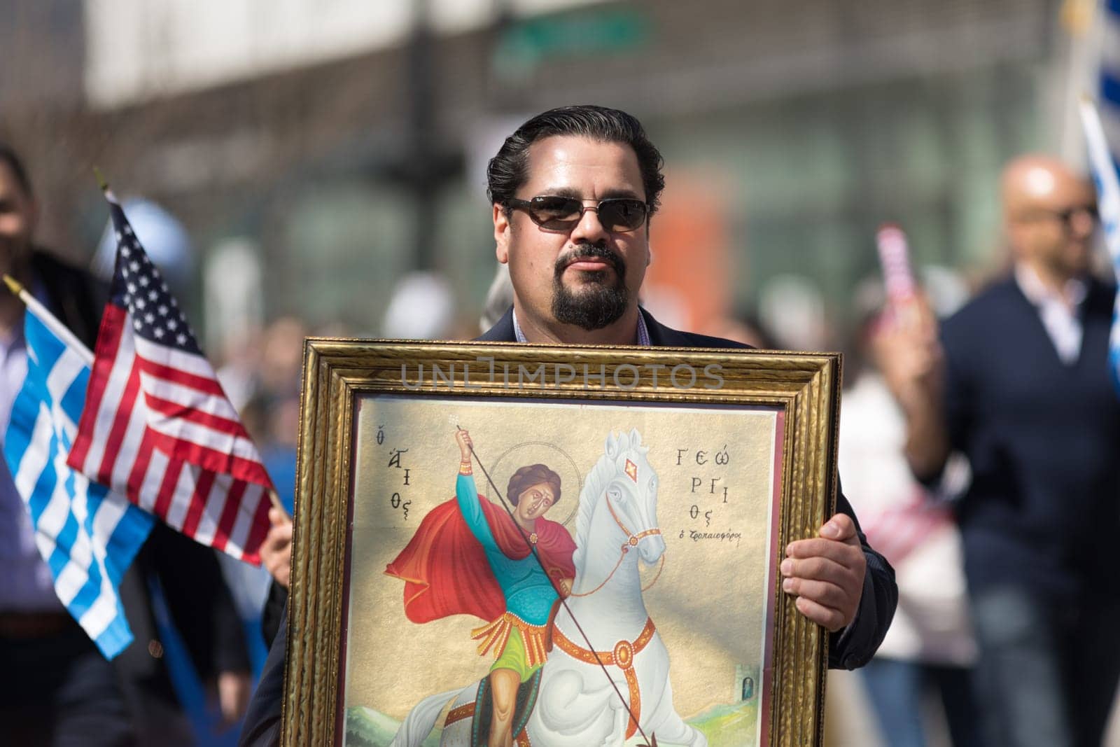 Chicago, Illinois, USA - April 29, 2018  Greek man carrying a painting of St. George from the Greek Orthodox Church during the Greek Independence  Day Parade