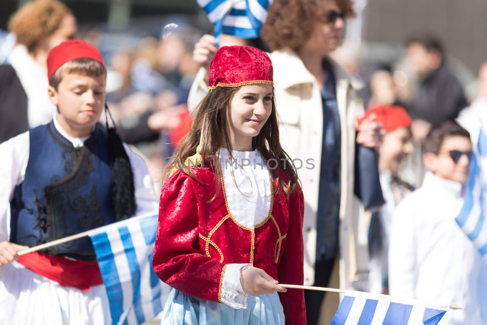 Chicago, Illinois, USA - April 29, 2018 Members of a greek school wearing traditional clothing and waving greek flags during the Greek Independence  Day Parade