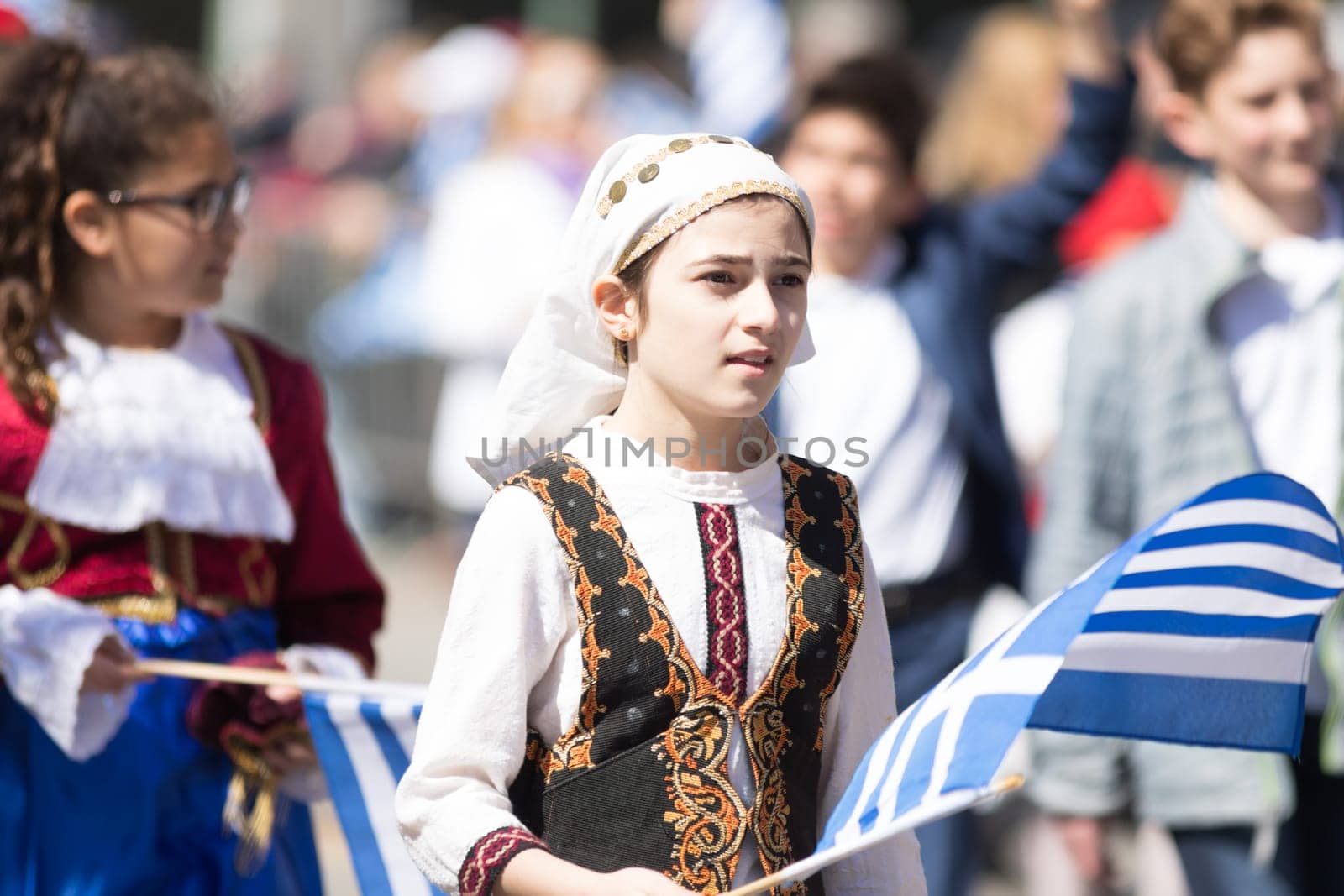 Chicago, Illinois, USA - April 29, 2018  Greek Children wearing traditional clothing and waving greek flags during the Greek Independence  Day Parade