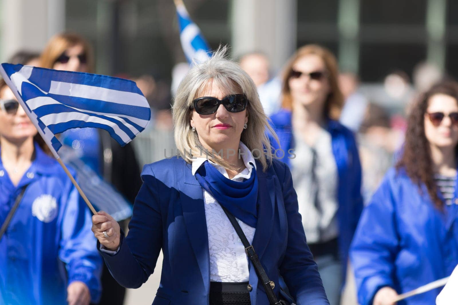 Chicago, Illinois, USA - April 29, 2018 Greek woman waving the greek flag during the Greek Independence  Day Parade