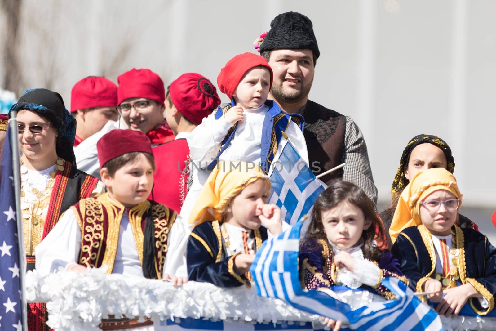 Chicago, Illinois, USA - April 29, 2018  Children wearing traditional clothing waving the greek flag during the Greek Independence  Day Parade