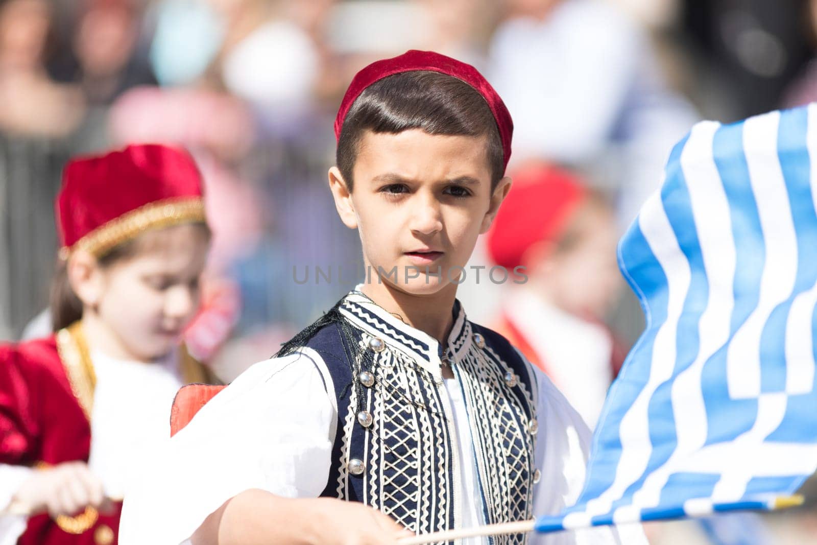 Chicago, Illinois, USA - April 29, 2018 Members of a greek school wearing traditional clothing and waving greek flags during the Greek Independence  Day Parade