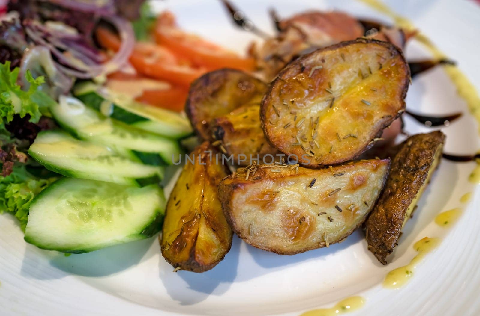Roasted potatoes with rosemary, served with summer salad as addition to the grilled bacon wrapped chicken