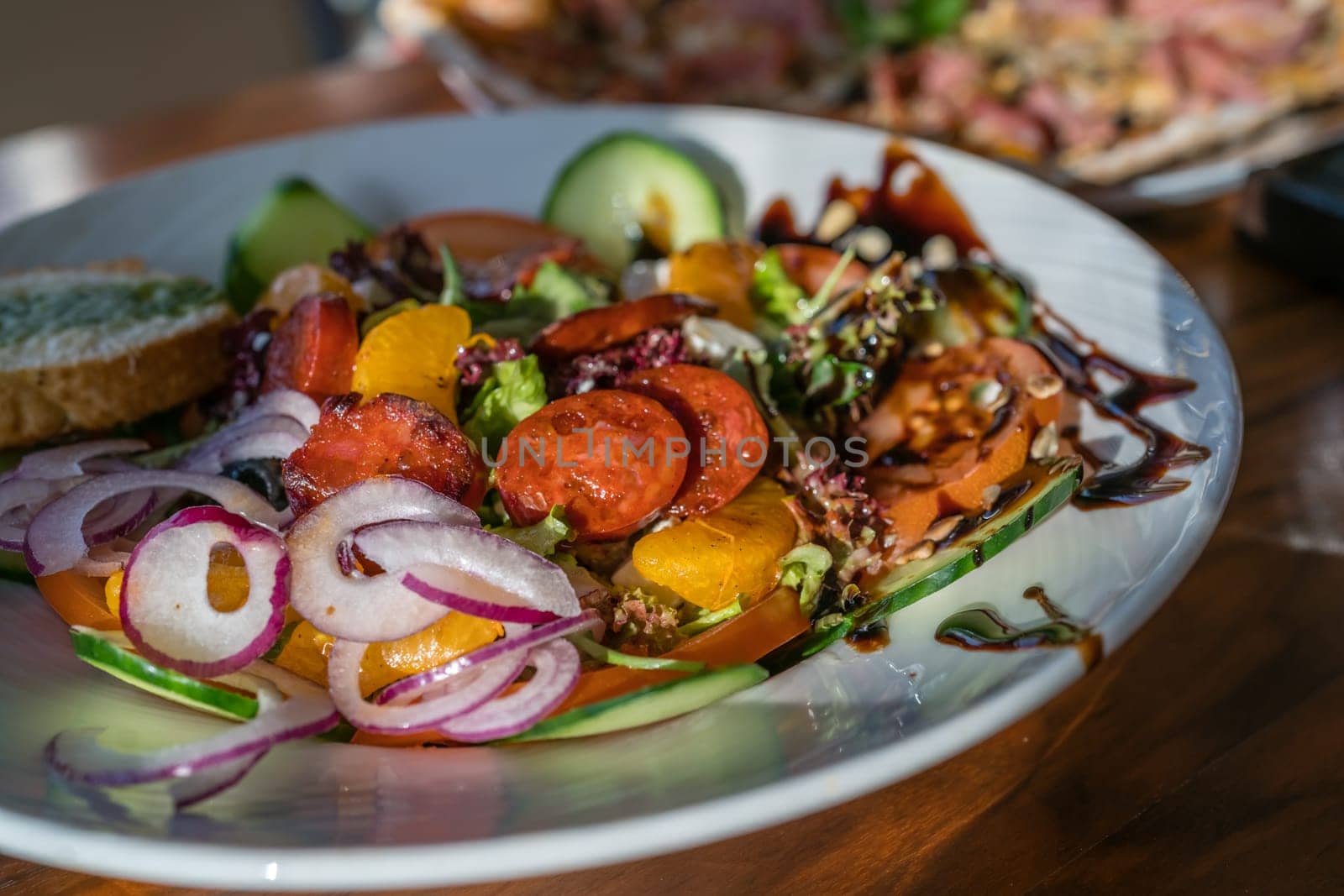 Close-up of a fresh spicy Spanish chorizo summer salad in a white plate
