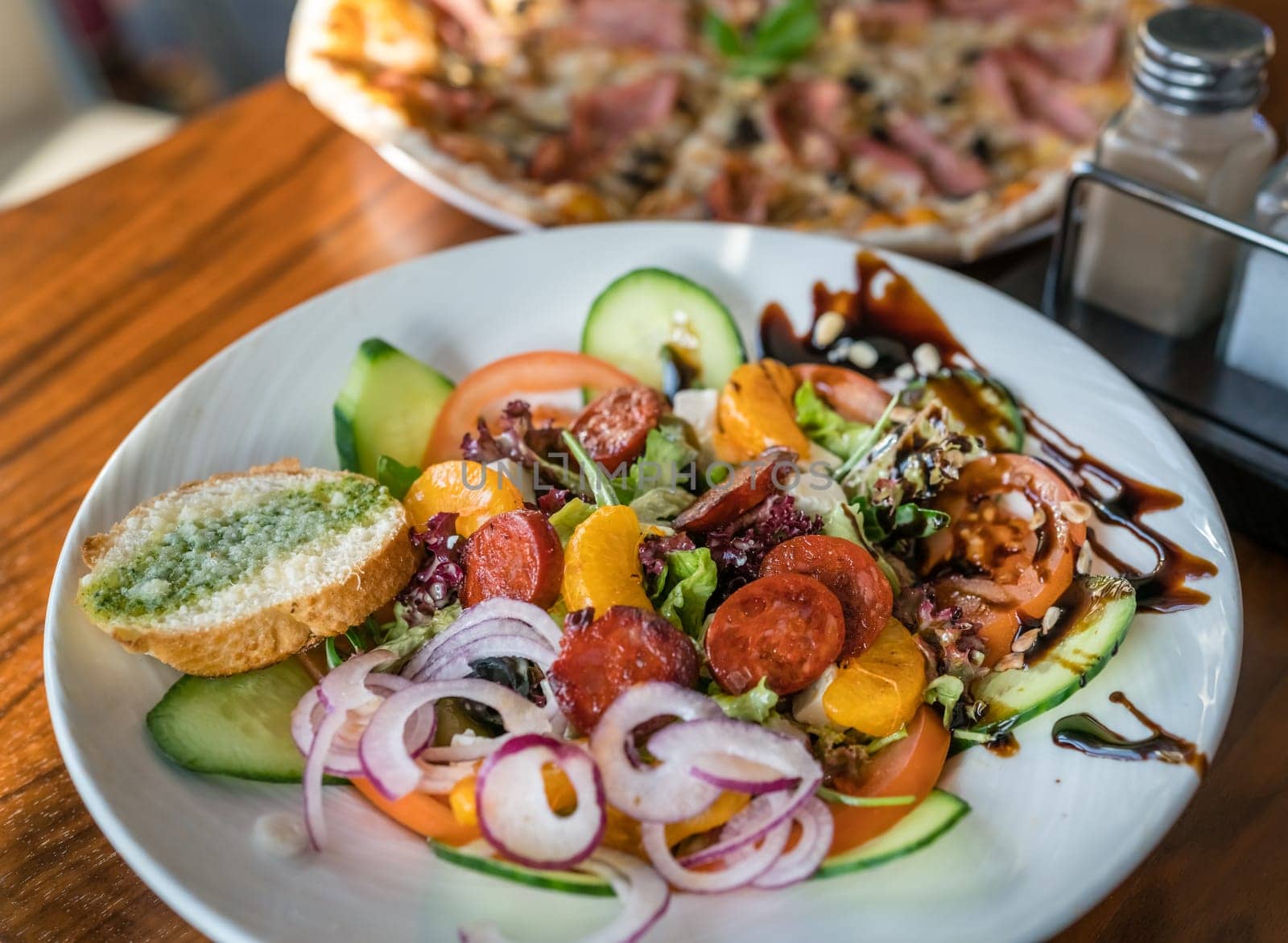 Close-up of a fresh spicy Spanish chorizo summer salad in a white plate