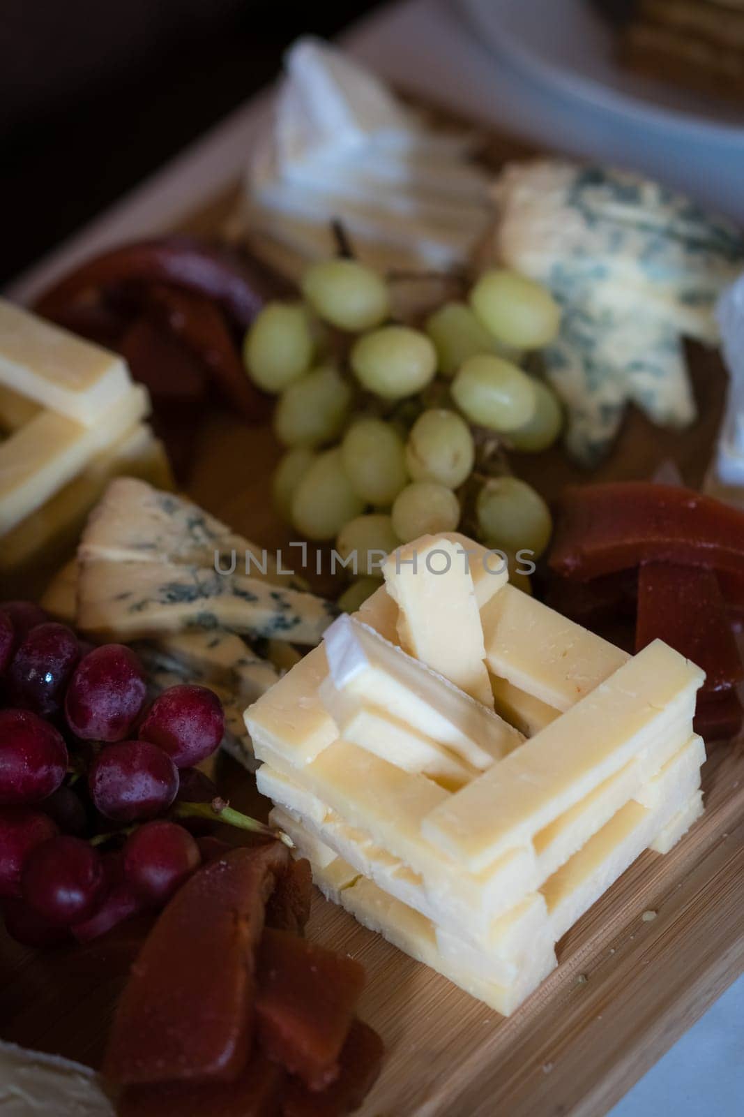 Cheese platter with different cheeses including brie, cheddar and blue cheese, served with grapes