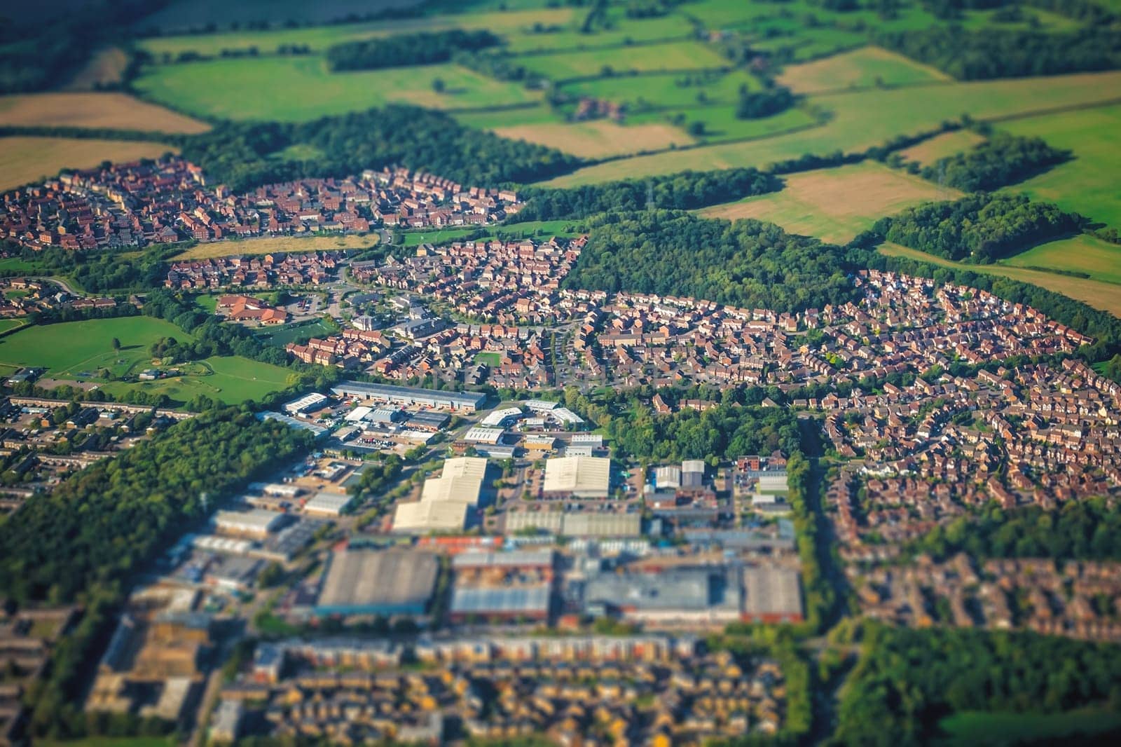 Aerial shot of the small town and rural landscape seen from the plane window, UK