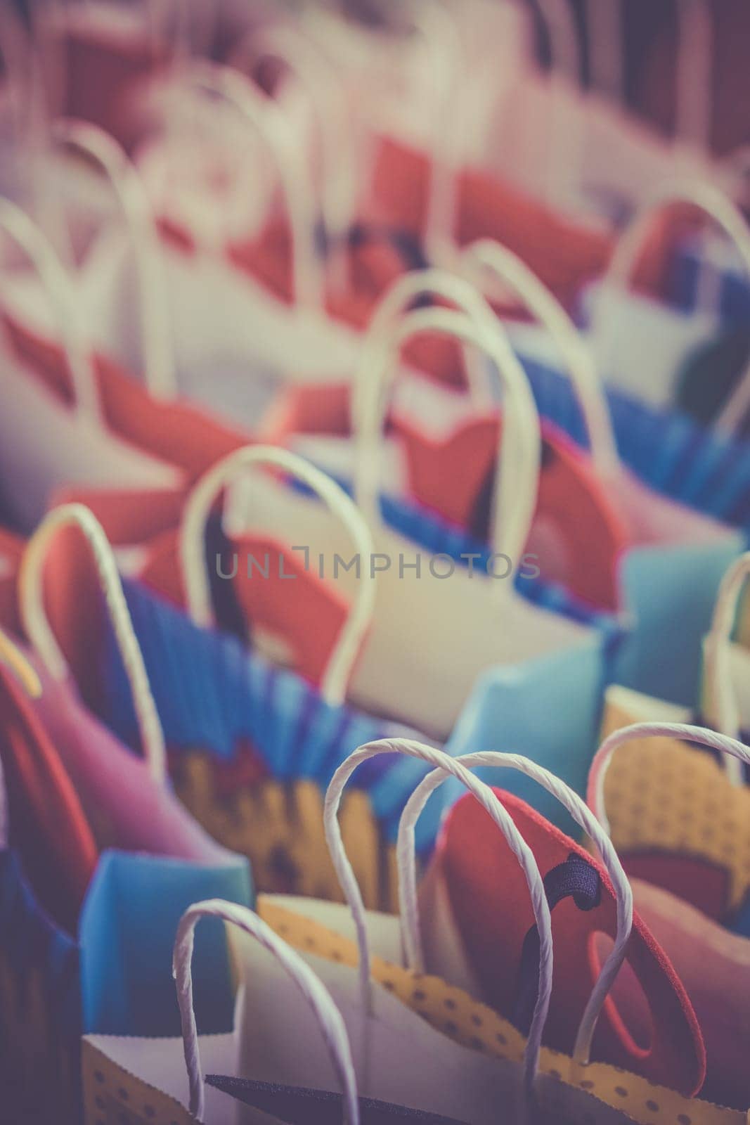 Row of colourful paper gift bags for sale on market
