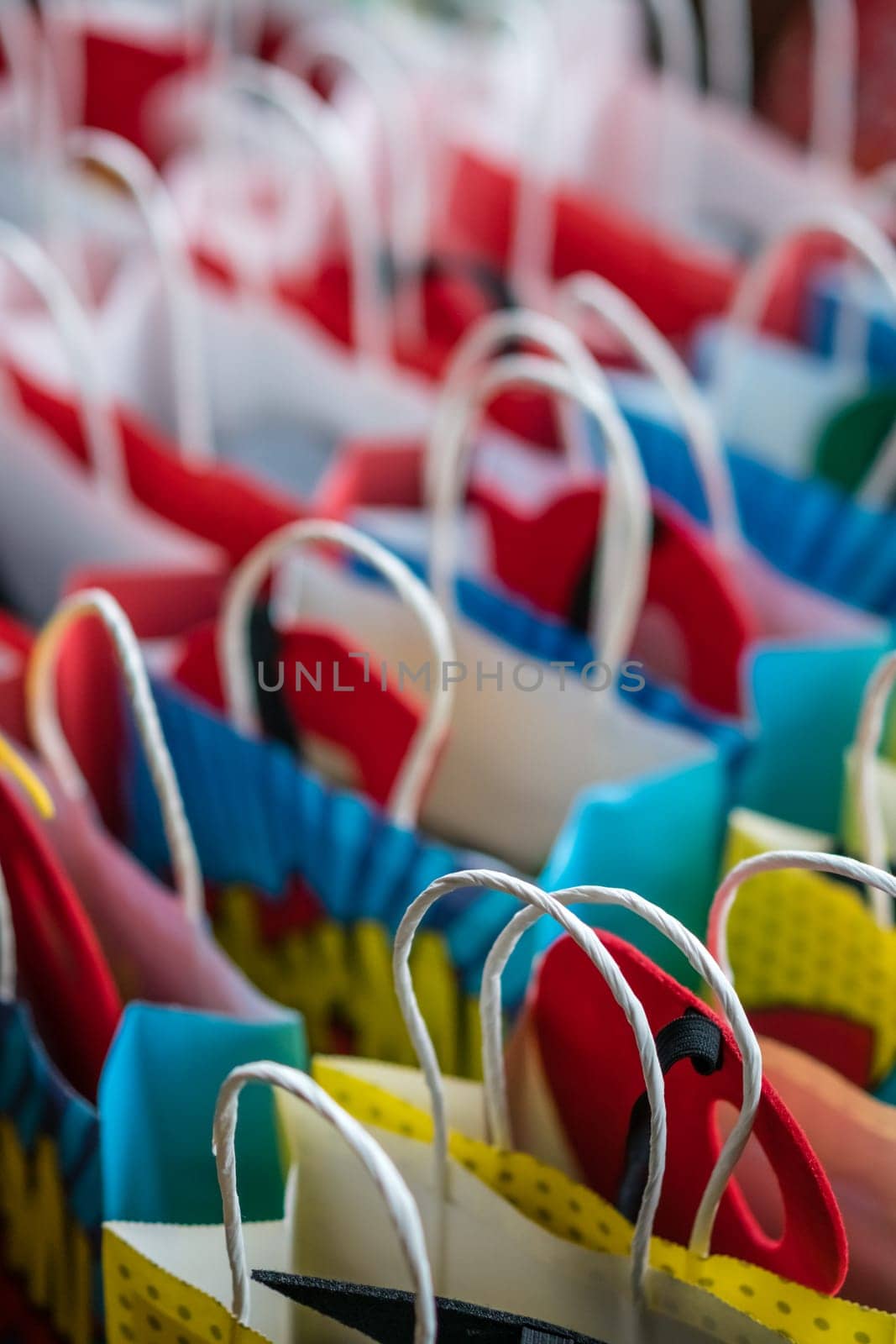 Row of colourful paper gift bags for sale on market