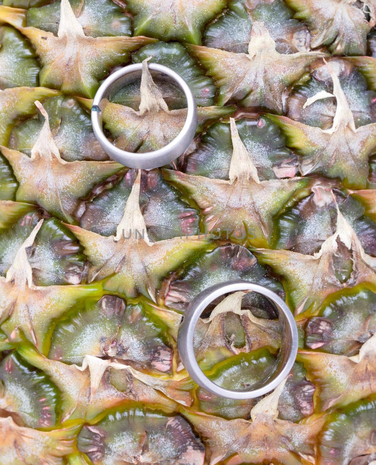 Wedding rings on a pineapple, isolated on a white background