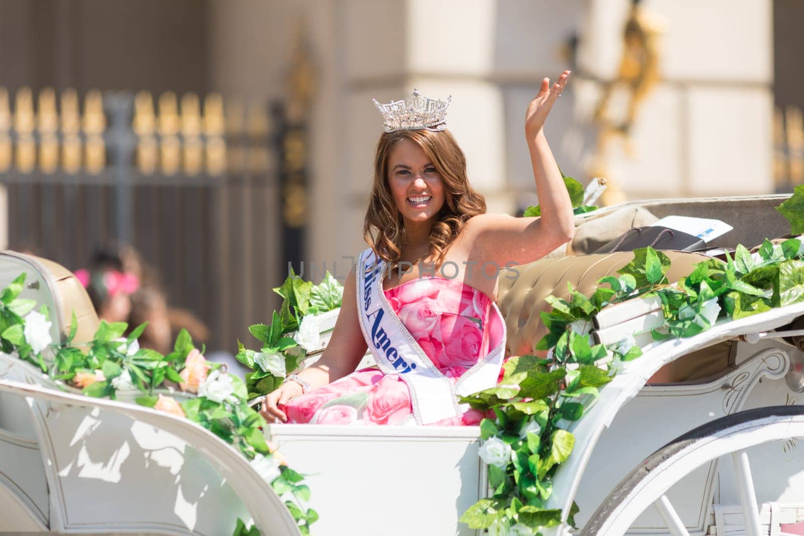 Washington, D.C., USA - April 14, 2018 Miss America on a white carriage with flowers going down the road in the 2018 National Cherry Blossom Parade