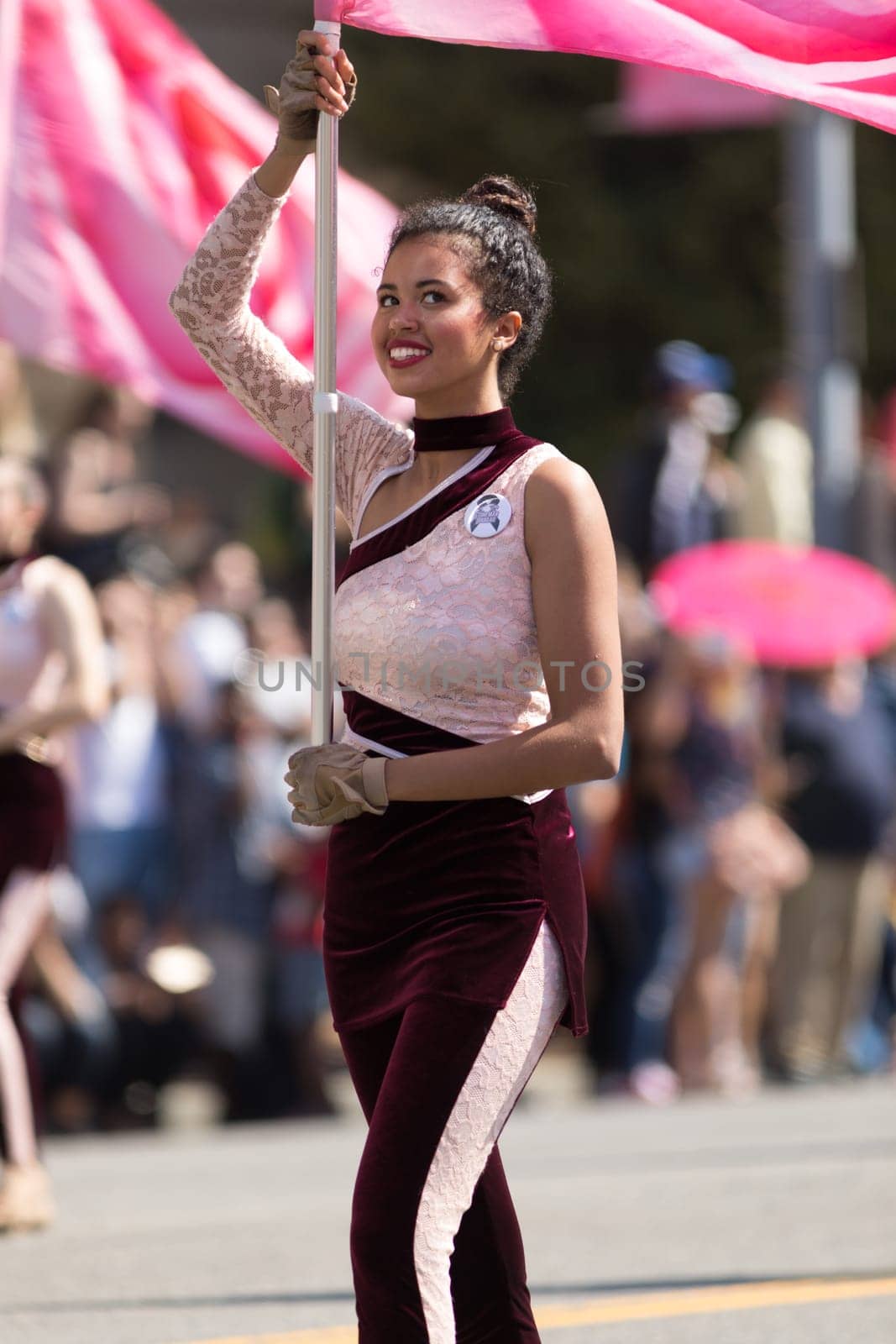 Washington, D.C., USA - April 14, 2018 Cheerleaders dancing with pink cherry flower flags in the 2018 National Cherry Blossom Parade