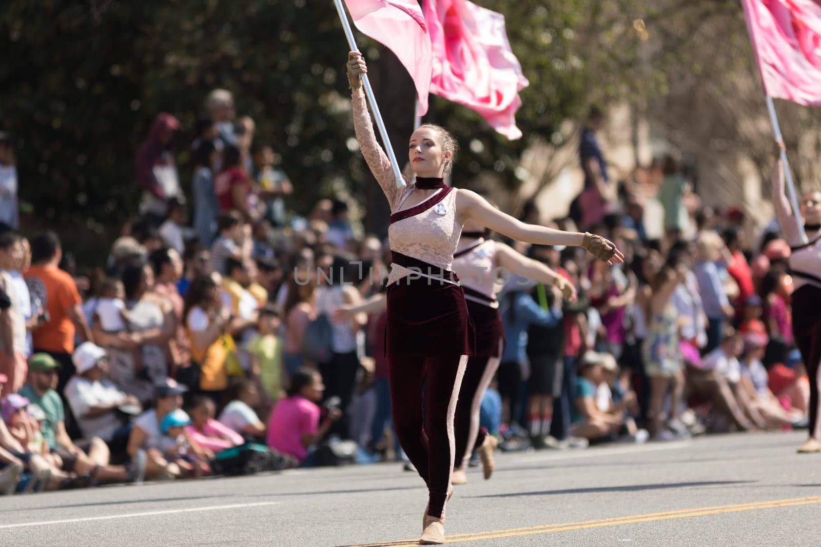 Washington, D.C., USA - April 14, 2018 Cheerleaders dancing with pink cherry flower flags in the 2018 National Cherry Blossom Parade