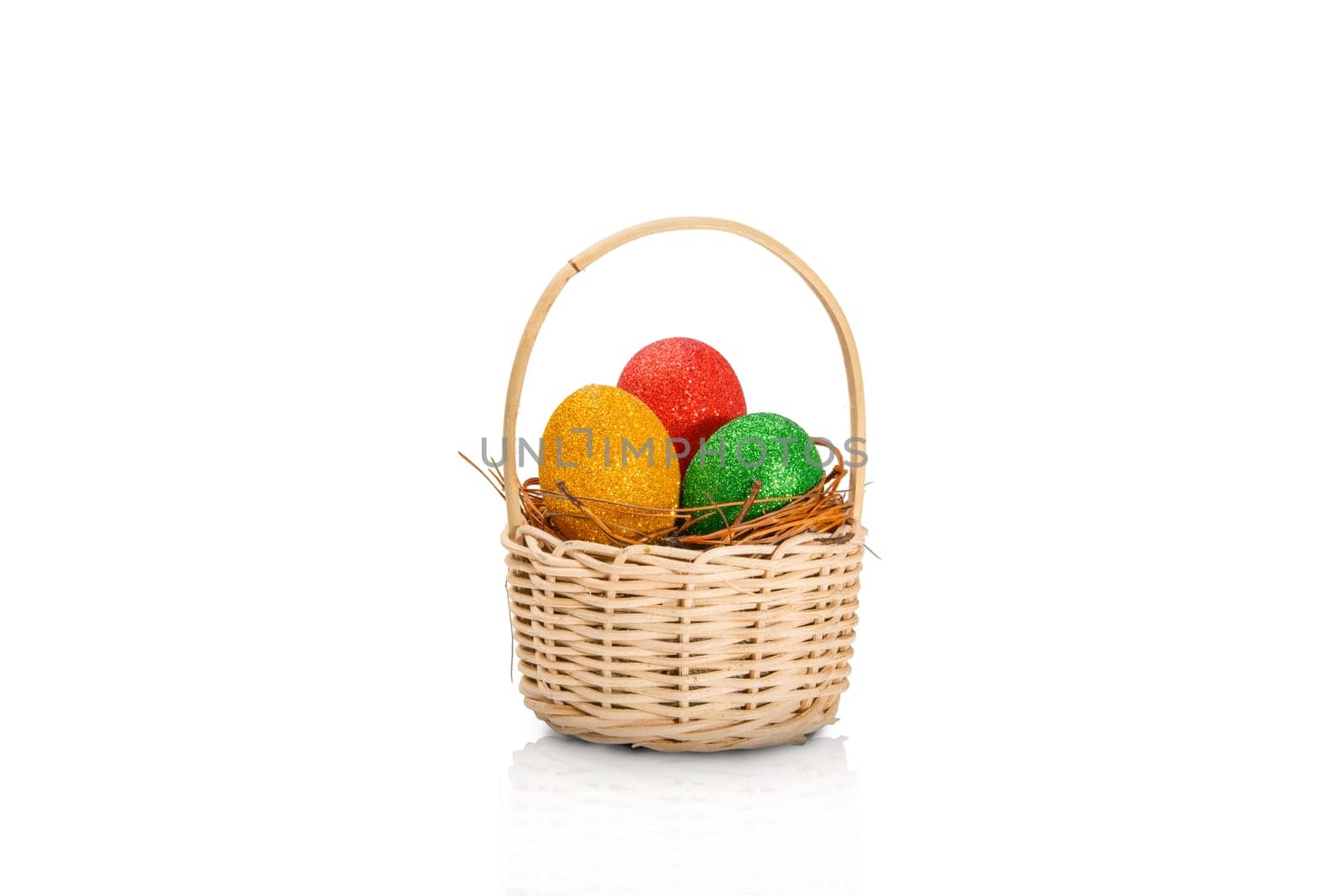 Colorful easter eggs with glitter in the nest on wooden basket isolated over white background. Happy Easter