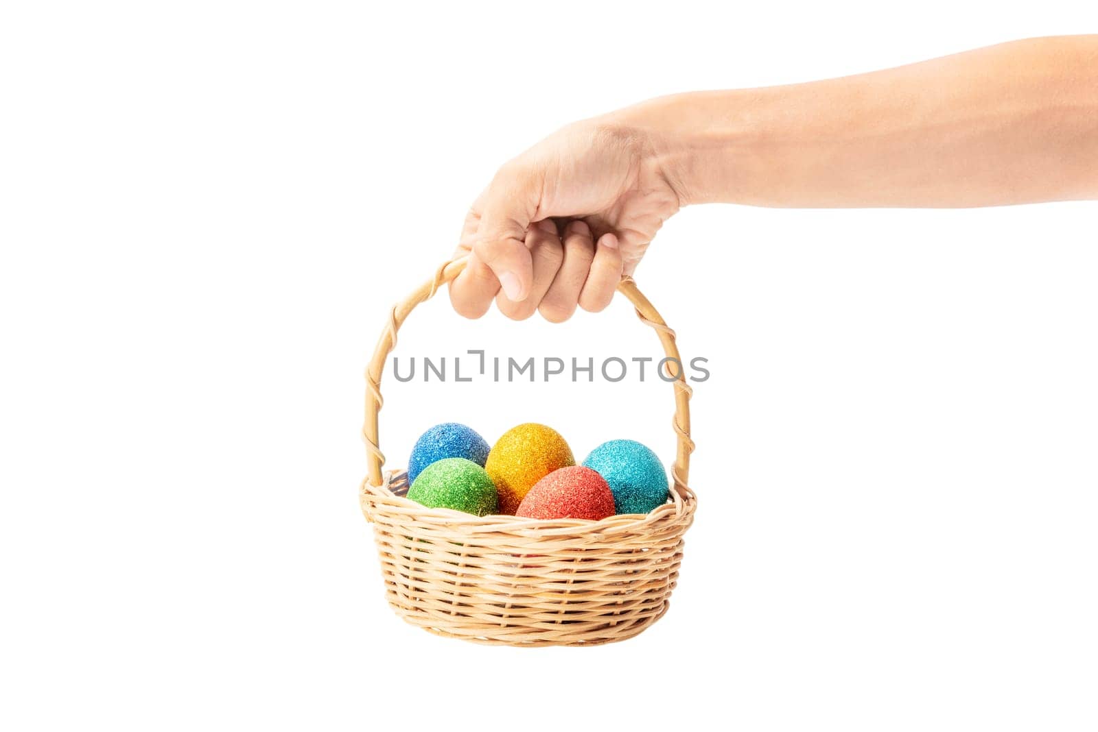 Human hands holding wooden basket with colorful easter eggs isolated over white background. Happy Easter