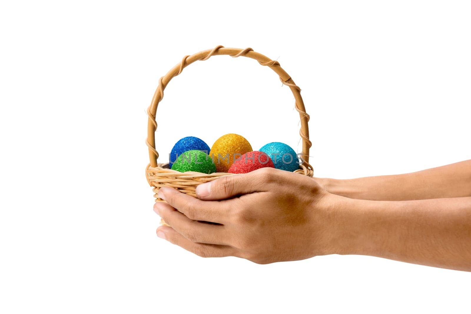 Human hands holding wooden basket with colorful easter eggs isolated over white background. Happy Easter