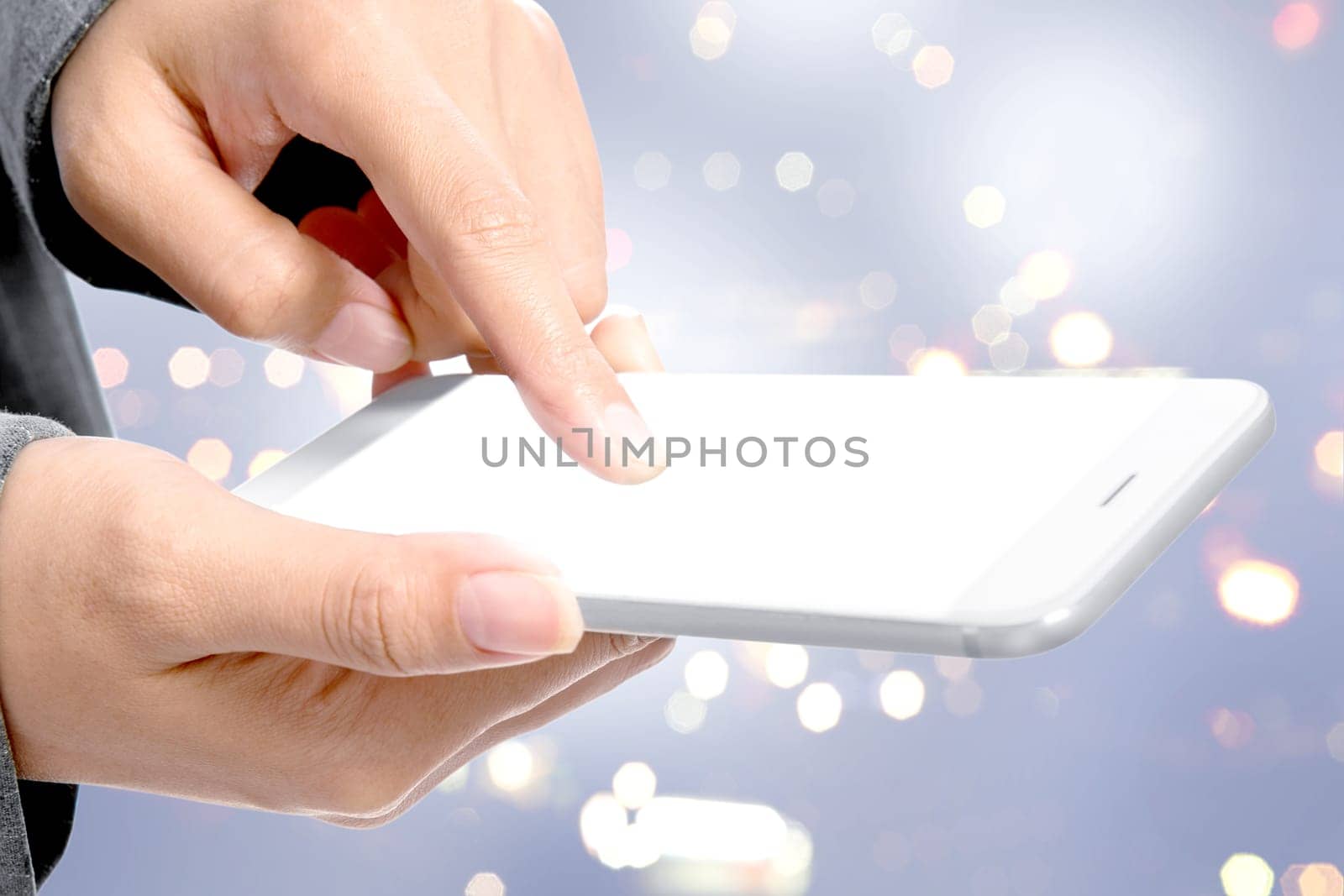 Business woman touching the empty white screen of mobile phone for copyspace over blurred light background