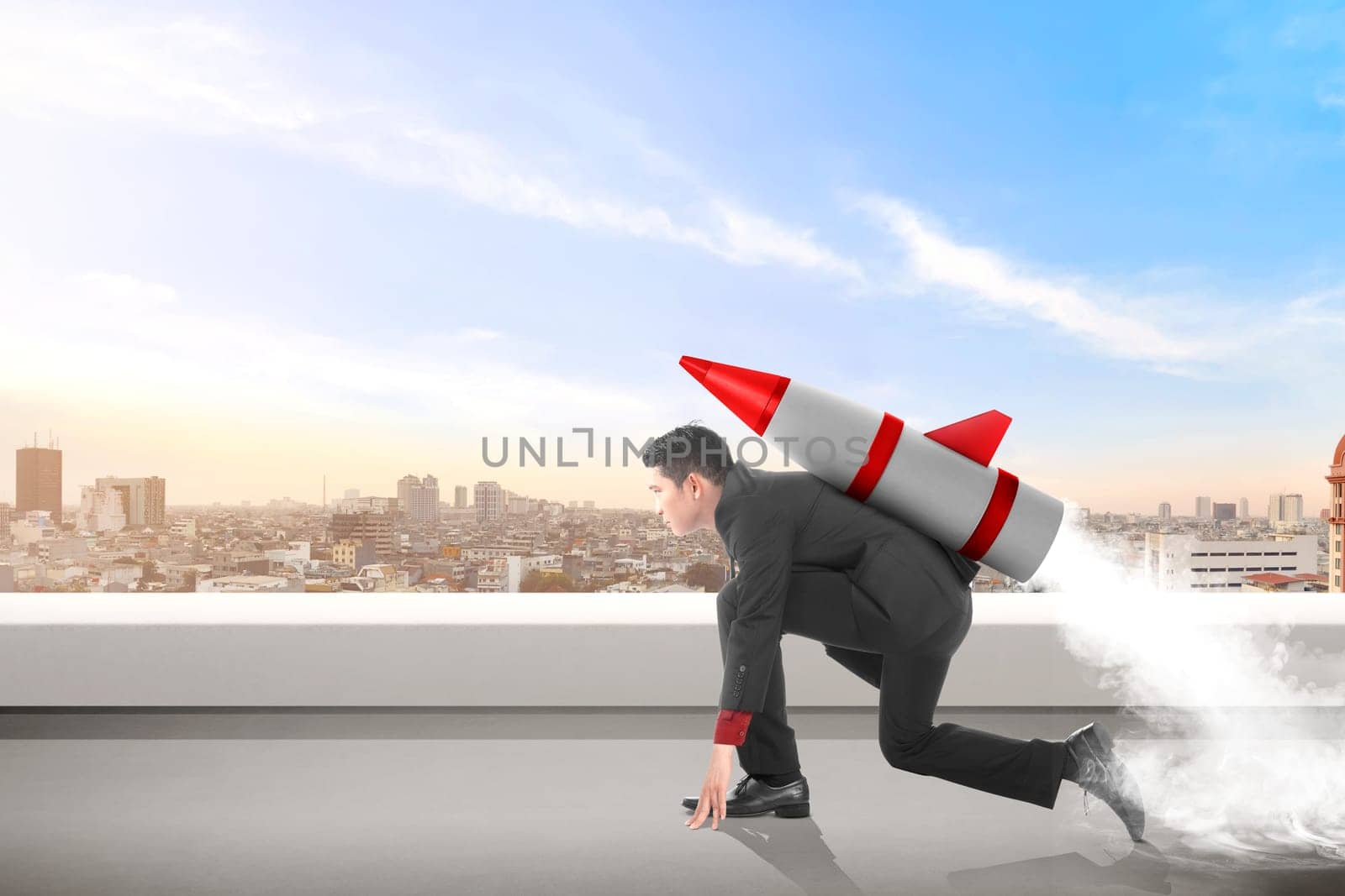 Young asian businessman on the rooftop with rocket ready to fly. Business concept