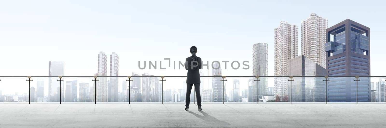 Rear view of asian business woman standing on modern terrace and looking at view on the city