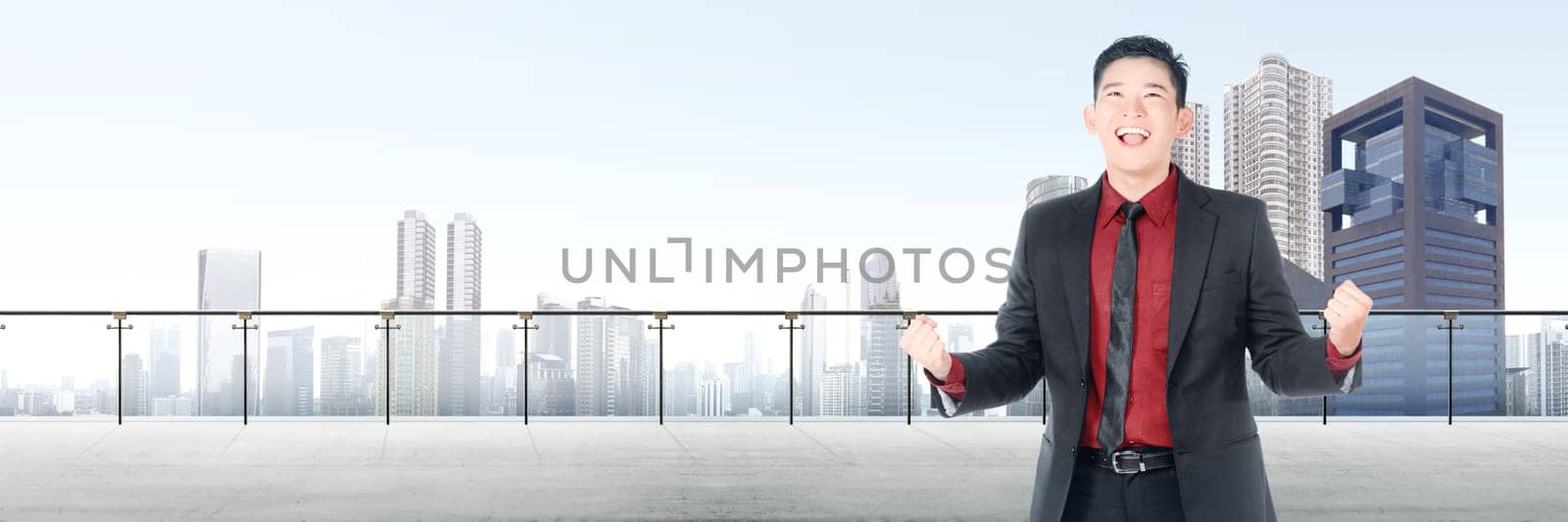 Successful asian businessman standing on modern terrace with cityscapes background