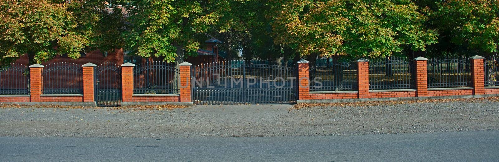 Simple metal fence with red bricks wall and pillars