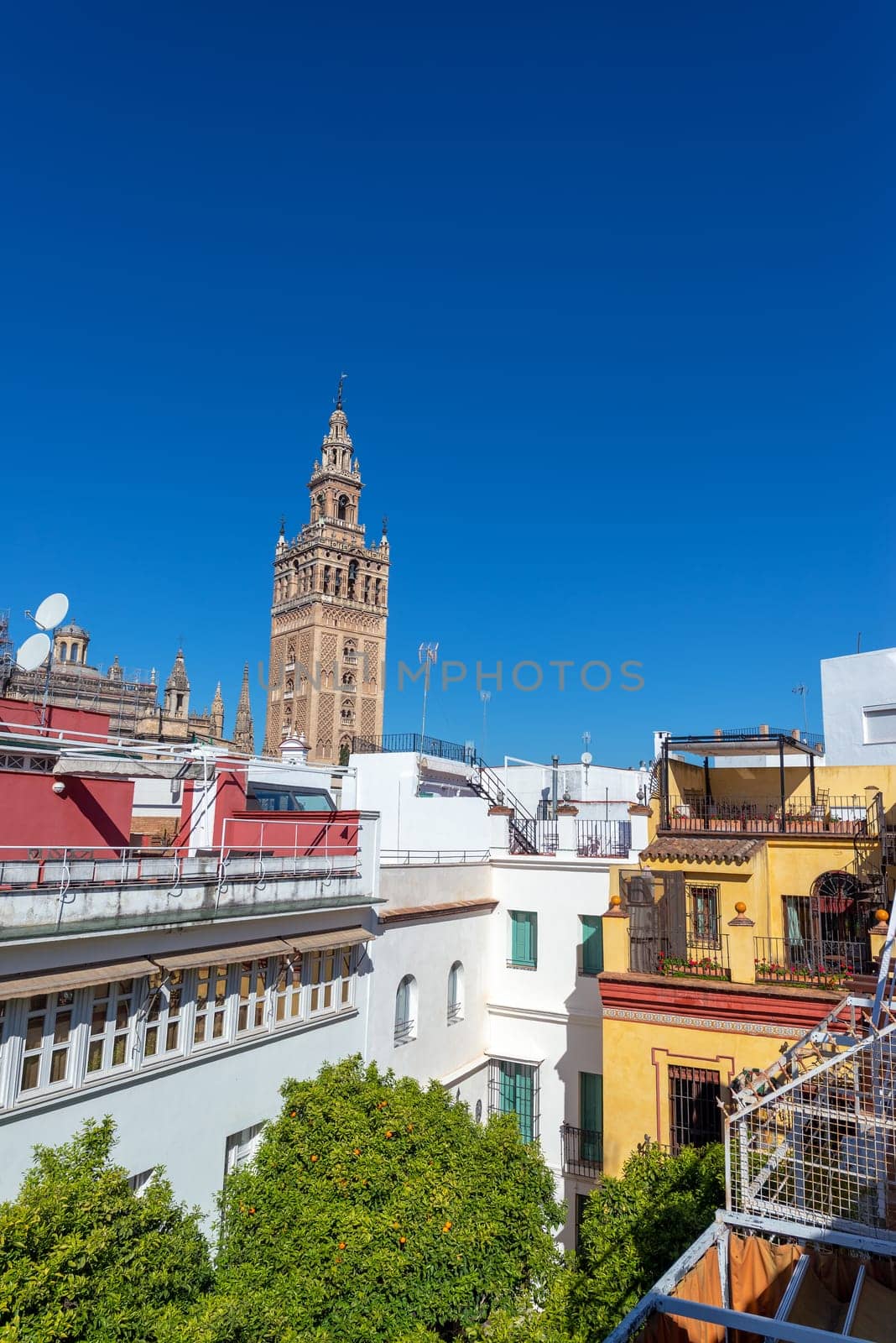 Apartment buildings with La Giralda bell tower of Seville Cathedral in the background in Seville, Spain