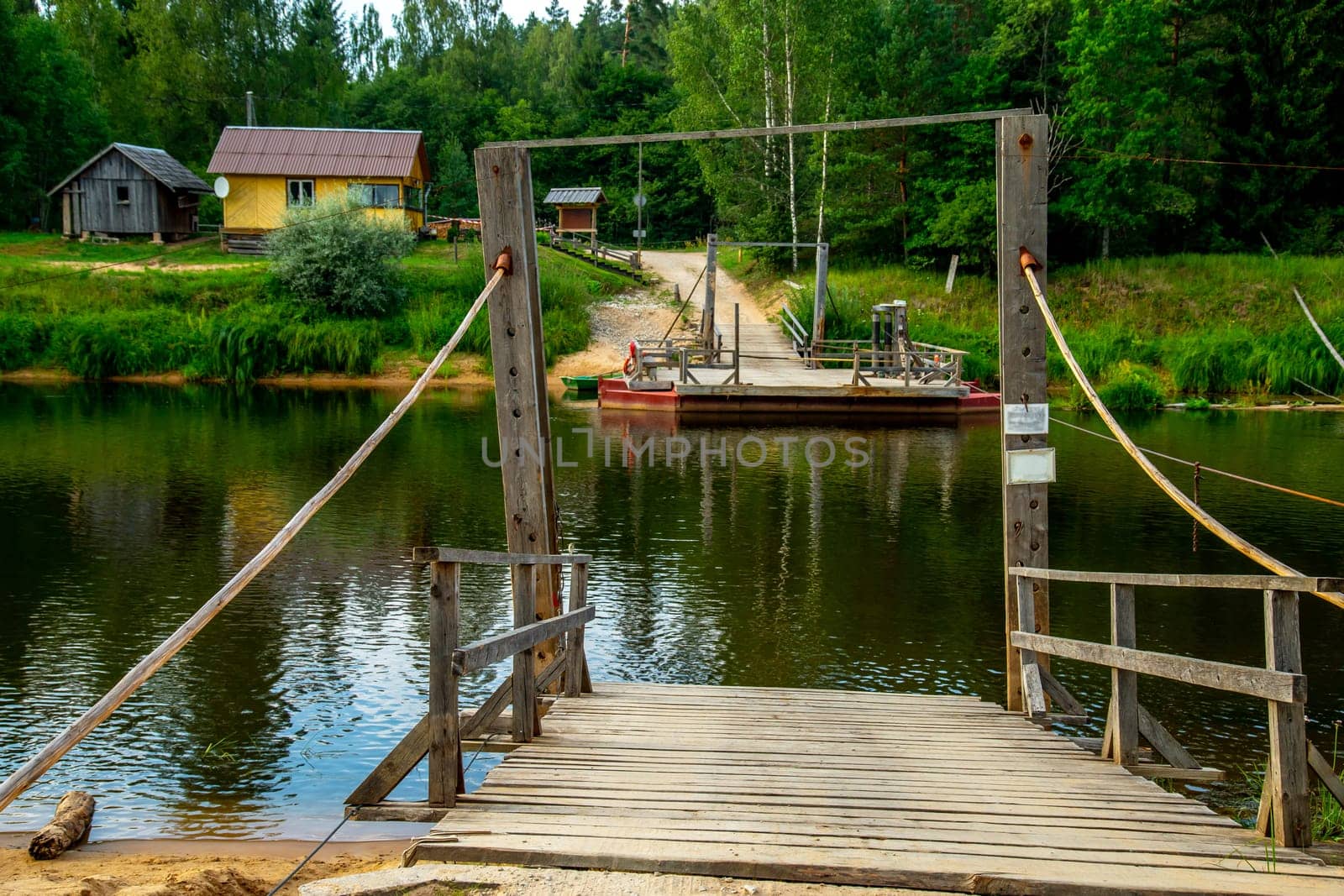Ligatne ferry crossing on the bank of river Gauja. Ferry across river in Latvia. The ferry over Gauja river is the only crossing of this type in the Baltic States. Ferry is made of two boats fastened together on which there is a plank layer...
