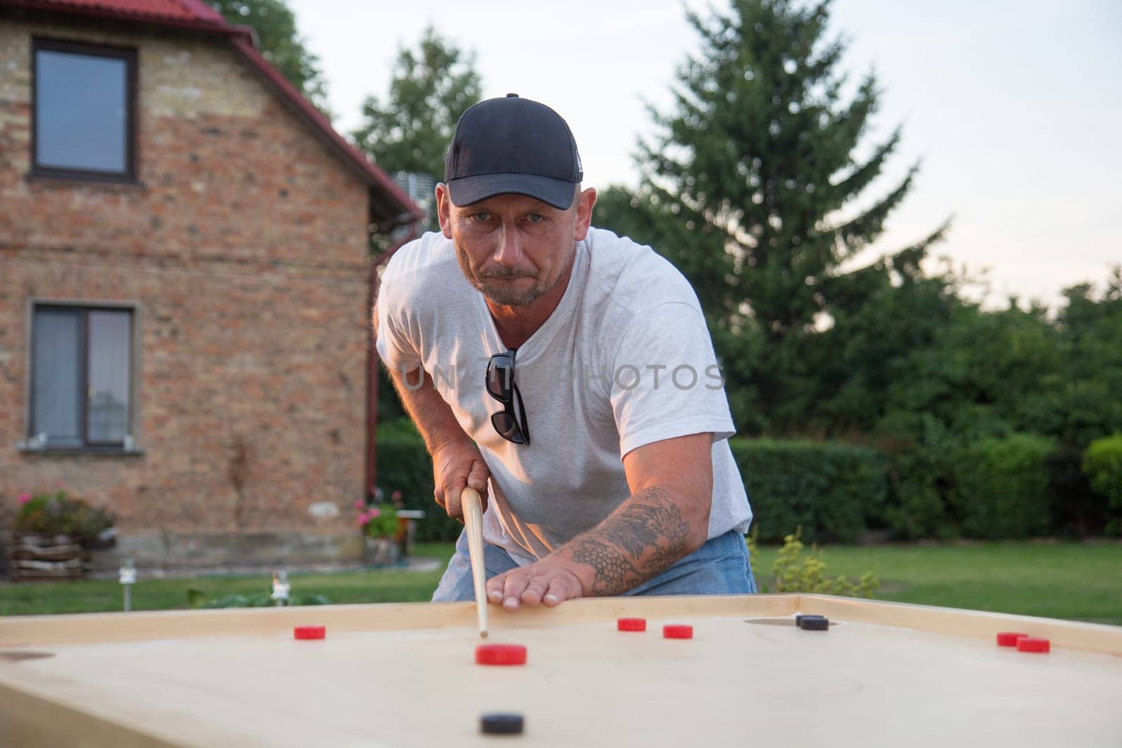Man playing Novuss in outdoors. Novuss is a national sport in Latvia similar to pocket billiards or pool.