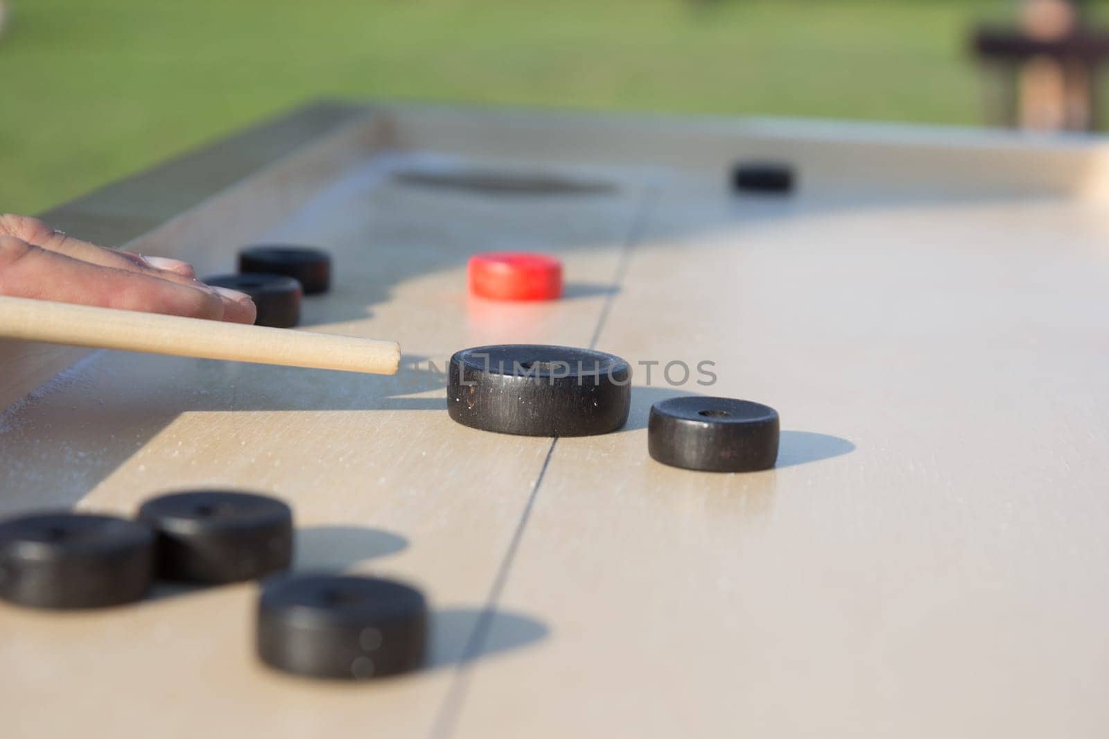 Man playing Novuss in outdoors. Novuss is a national sport in Latvia similar to pocket billiards or pool.