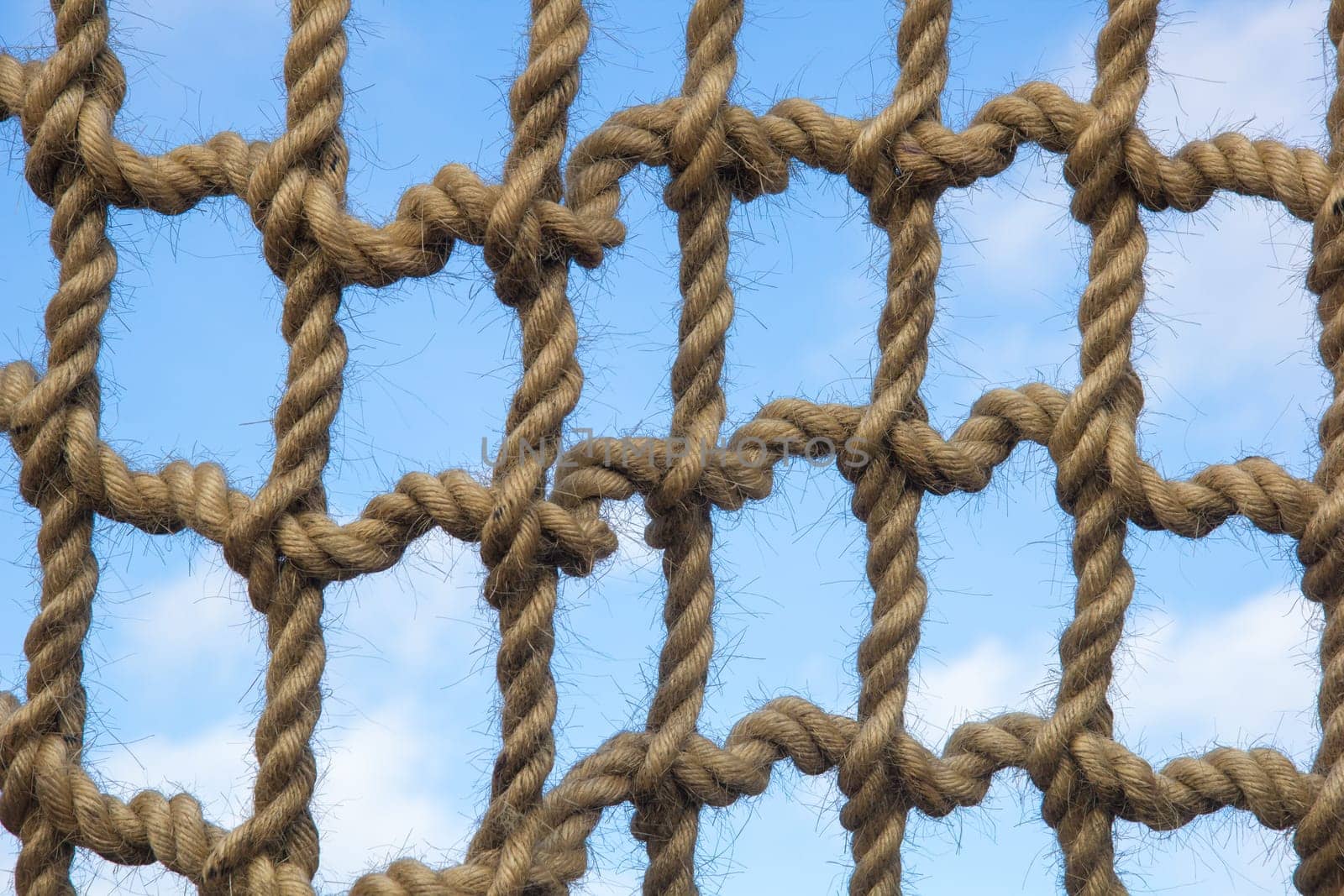 Net from large ropes against blue sky