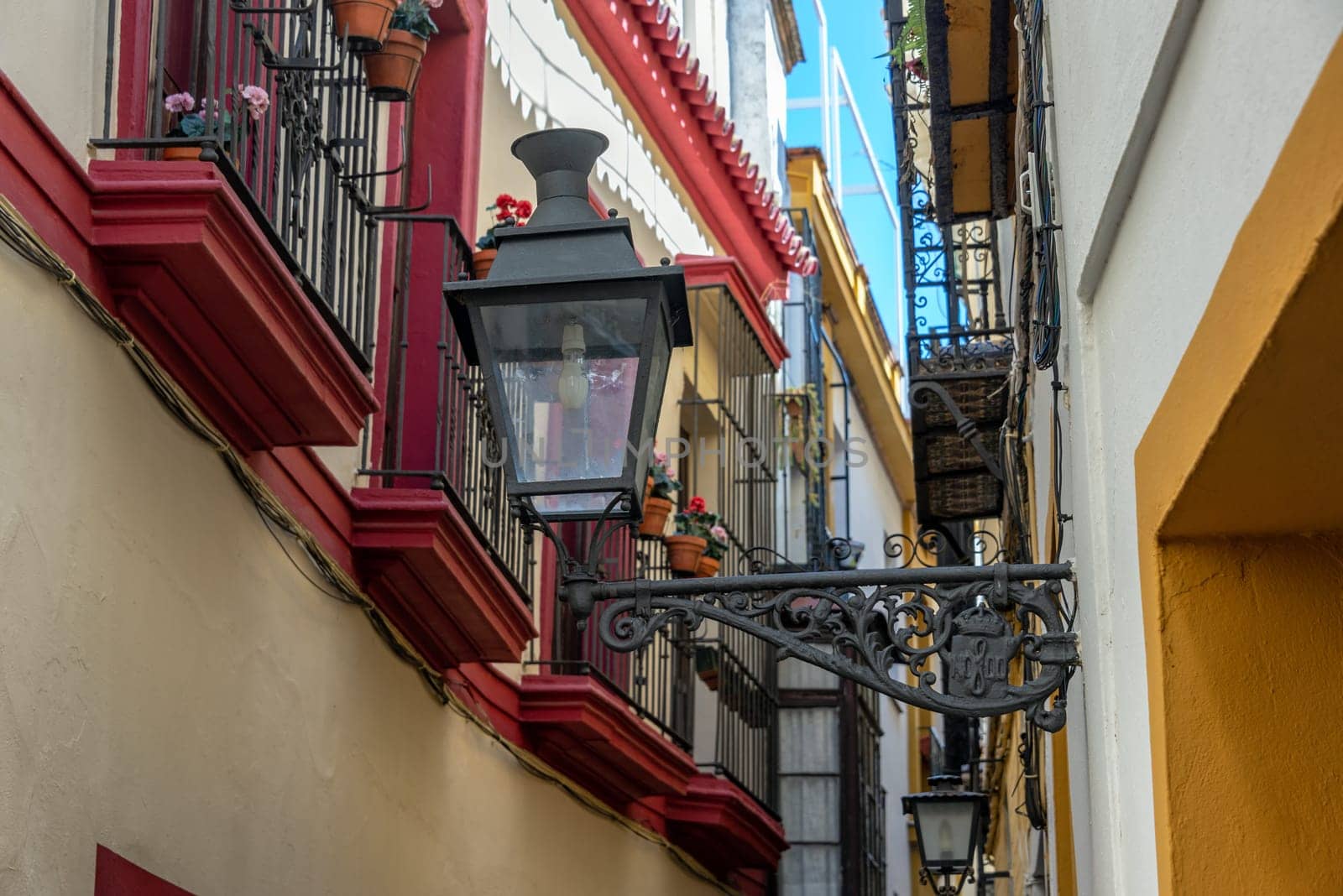 Old street light in a narrow street in Seville, Spain