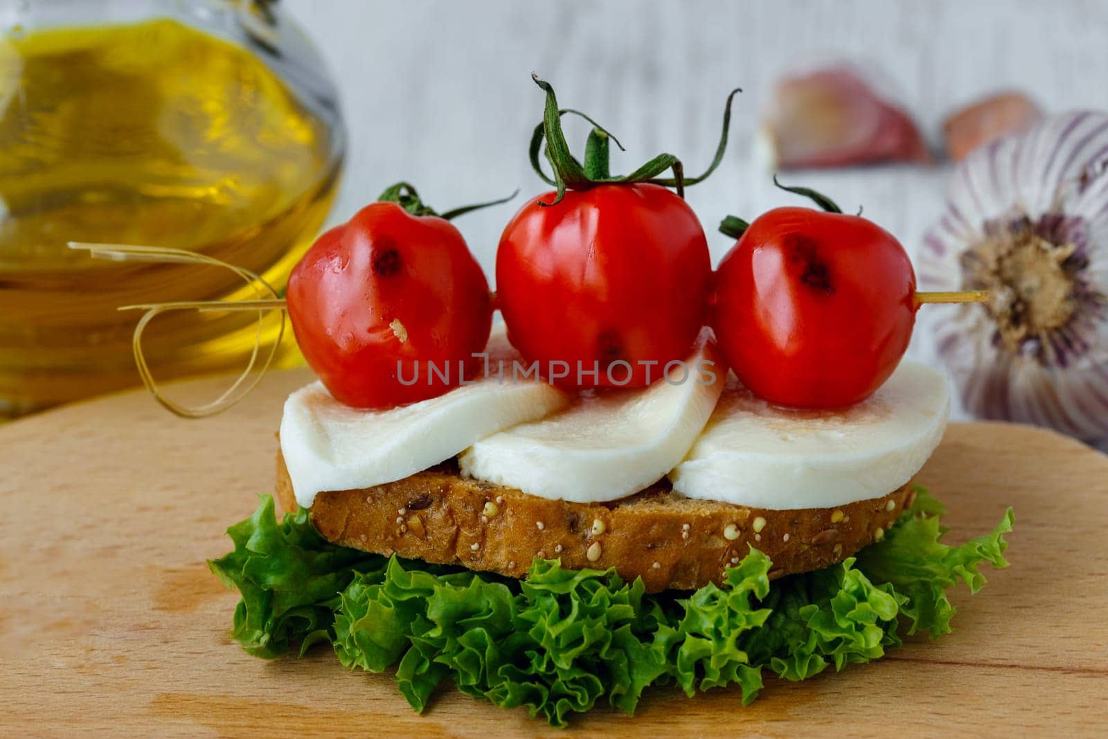 Bruschetta with mozzarella and cherry tomatoes on a sheet of lettuce
