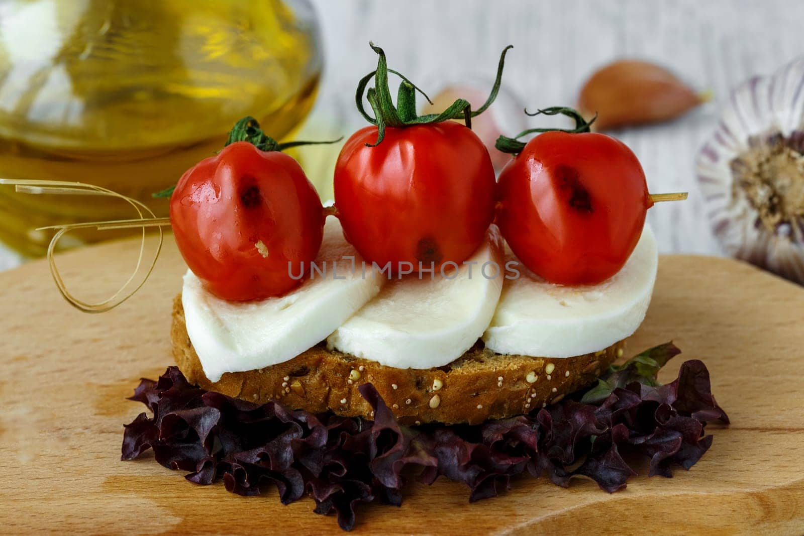 Bruschetta with mozzarella and cherry tomatoes on a sheet of lettuce