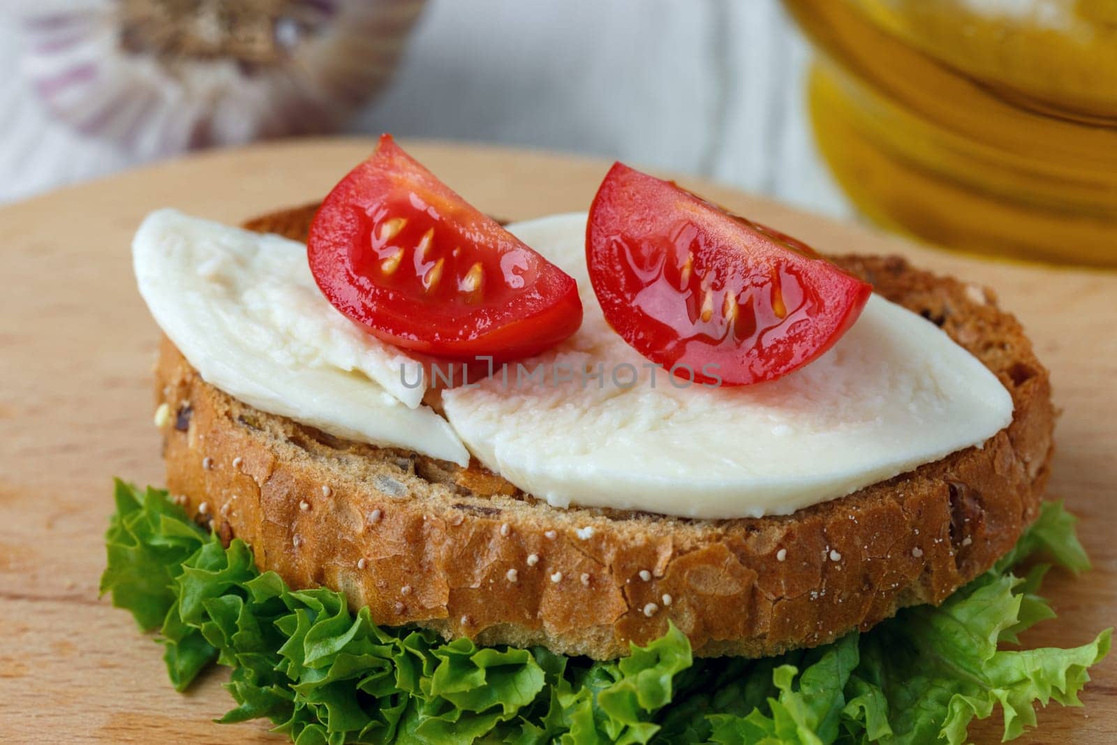 Bruschetta with mozzarella and cherry tomatoes on a sheet of lettuce
