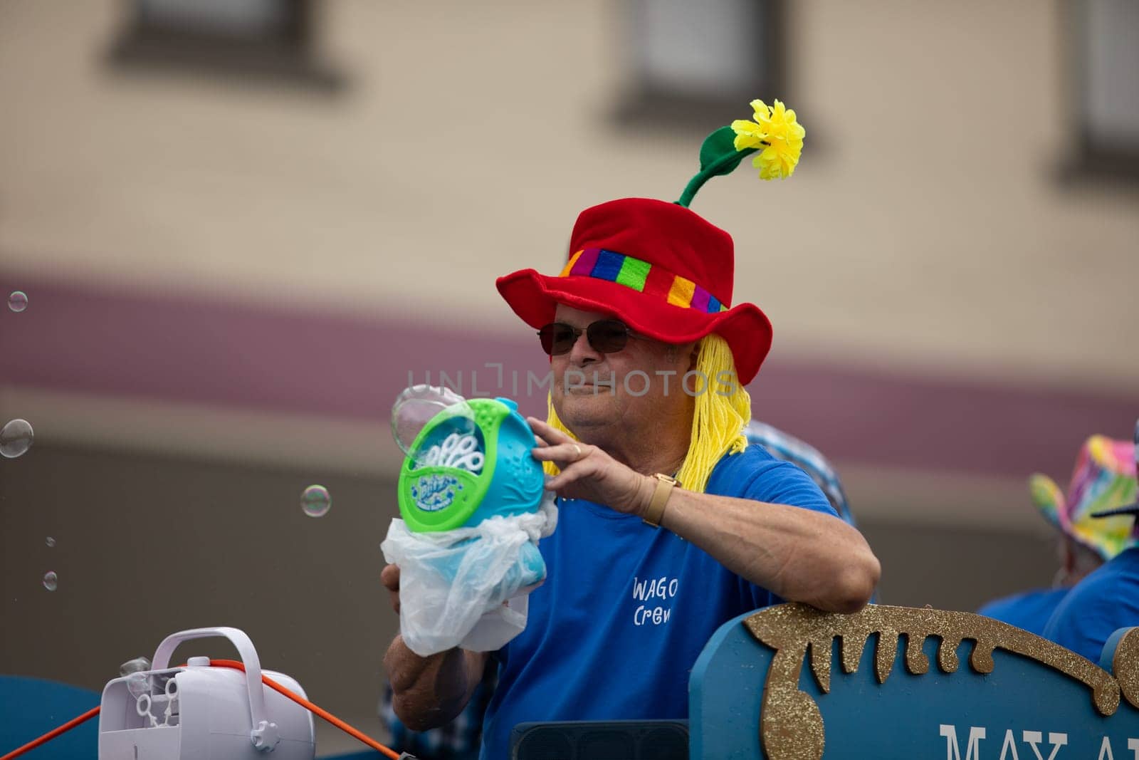 Peru, Indiana, USA - July 21, 2018 Man wearing a hat with a flower making bubbles with a machine at the Circus City Festival Parade