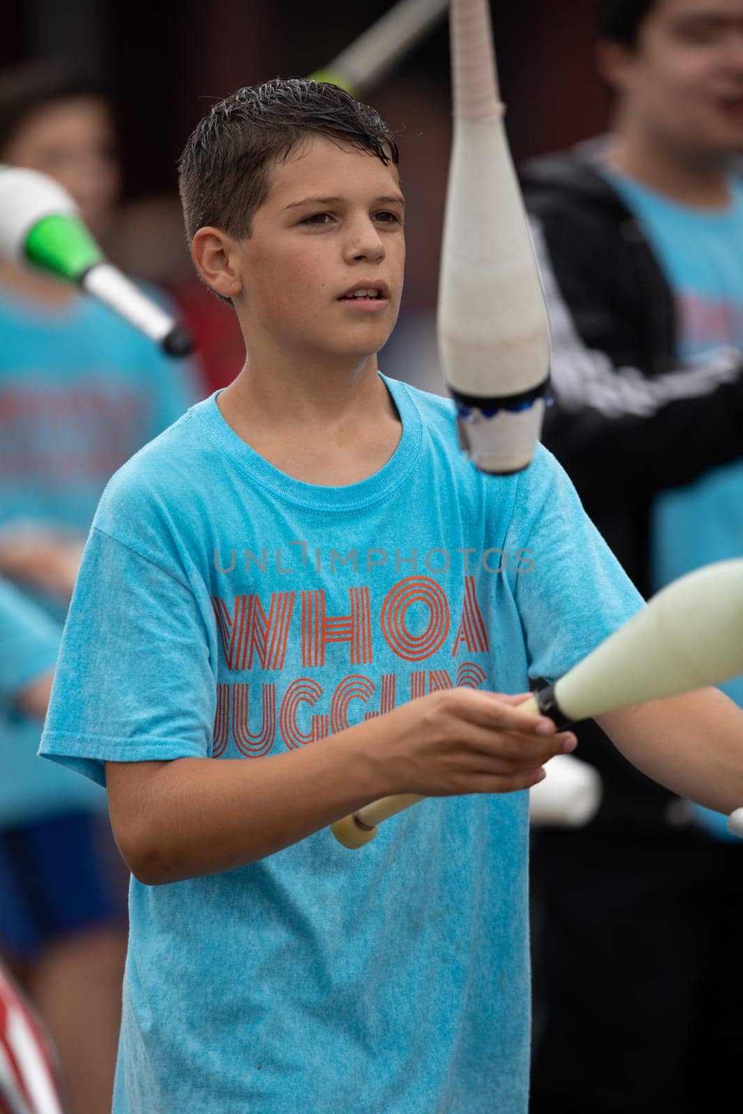 Peru, Indiana, USA - July 21, 2018 Young men wearing shirts that say Whoa Juggling, juggling bowling pins at the Circus City Festival Parade