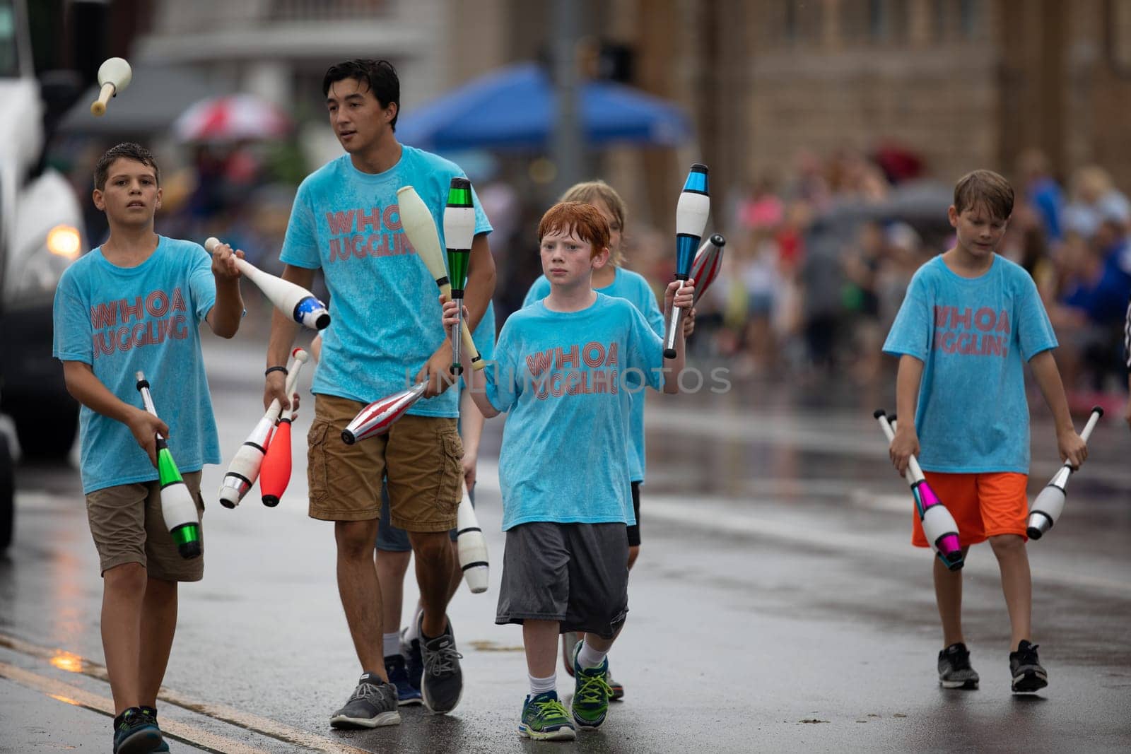 Peru, Indiana, USA - July 21, 2018 Young men wearing shirts that say Whoa Juggling, juggling bowling pins at the Circus City Festival Parade