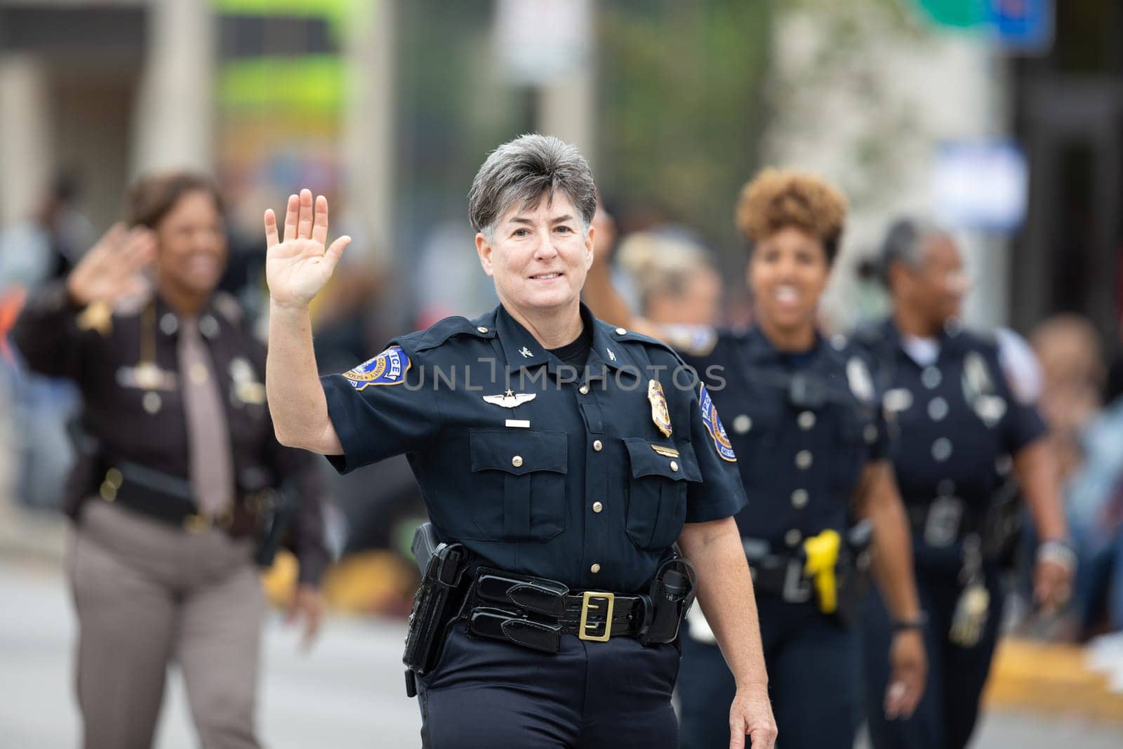 Indianapolis, Indiana, USA - September 22, 2018: The Circle City Classic Parade, Female police officers going down the road waving at spectators