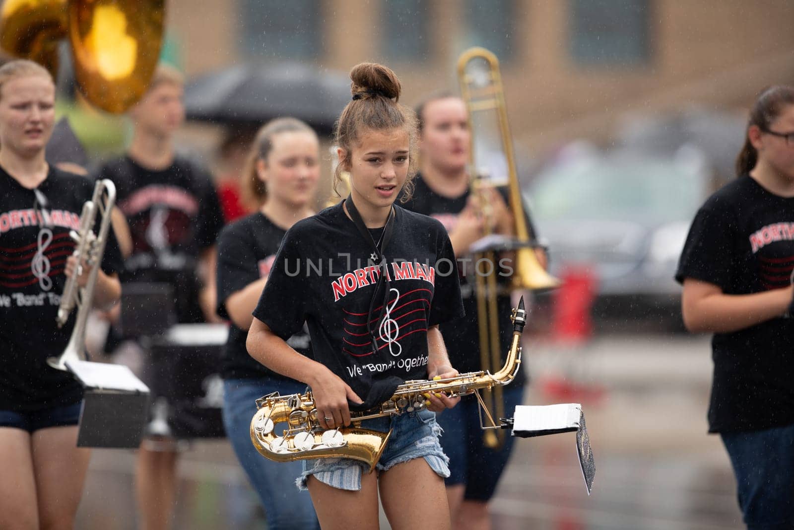 Peru, Indiana, USA - July 21, 2018 Under heavy rain Members of the North Miami High school marching band perform at the Circus City Festival Parade