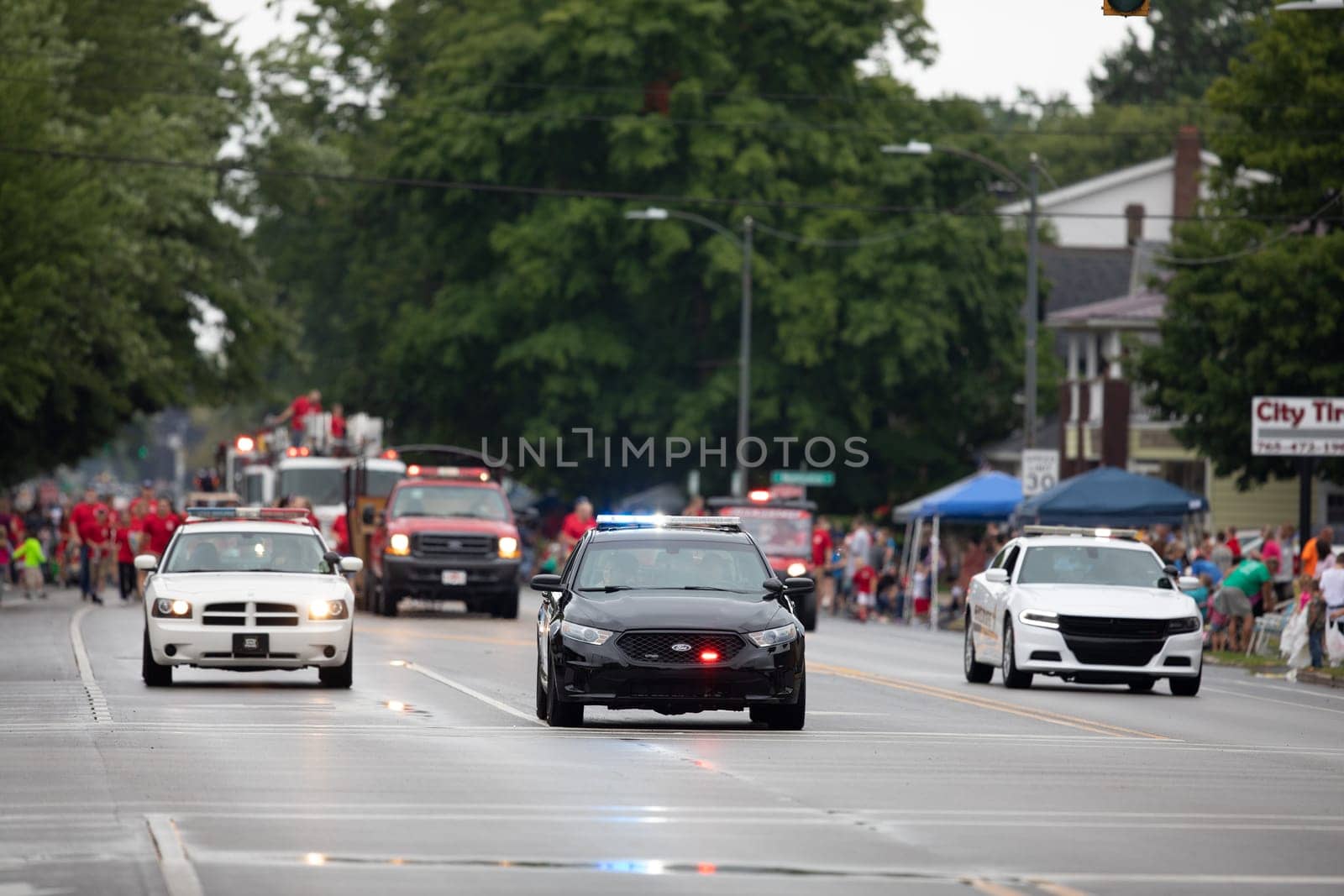 Peru, Indiana, USA - July 21, 2018 Police Officers and fire fighters going down the road at the Circus City Festival Parade