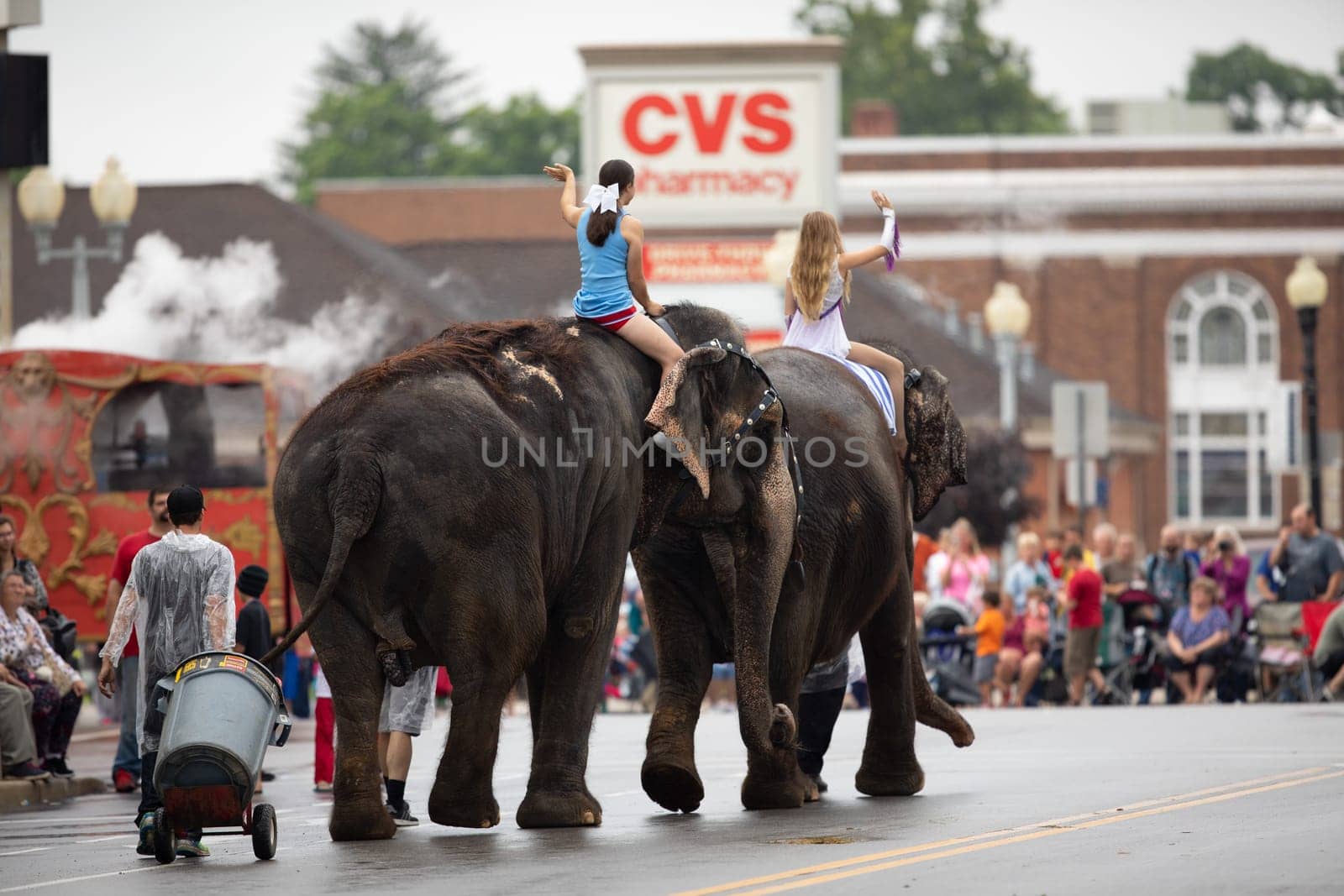 Peru, Indiana, USA - July 21, 2018 Young women riding elephants down the road at the Circus City Festival Parade